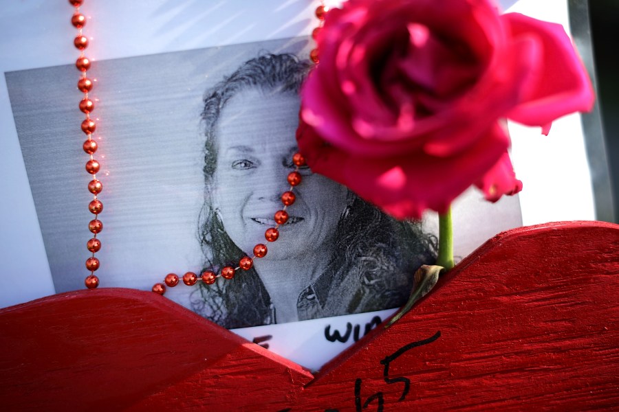 Beads, a wooden heart and flowers decorate a photograph of Wendi Winters at a makeshift memorial outside the Capitol Gazette offices July 2, 2018, in Annapolis, Md. Winters, 65, a local news reporter and community columnist, was killed in the shooting along with her colleagues, Gerald Fischman, 61, an editorial editor; Rob Hiaasen, 59, an editor and columnist; John McNamara, 56, a sports reporter and editor; and Rebecca Smith, 34, a sales assistant. (Credit: Chip Somodevilla/Getty Images)