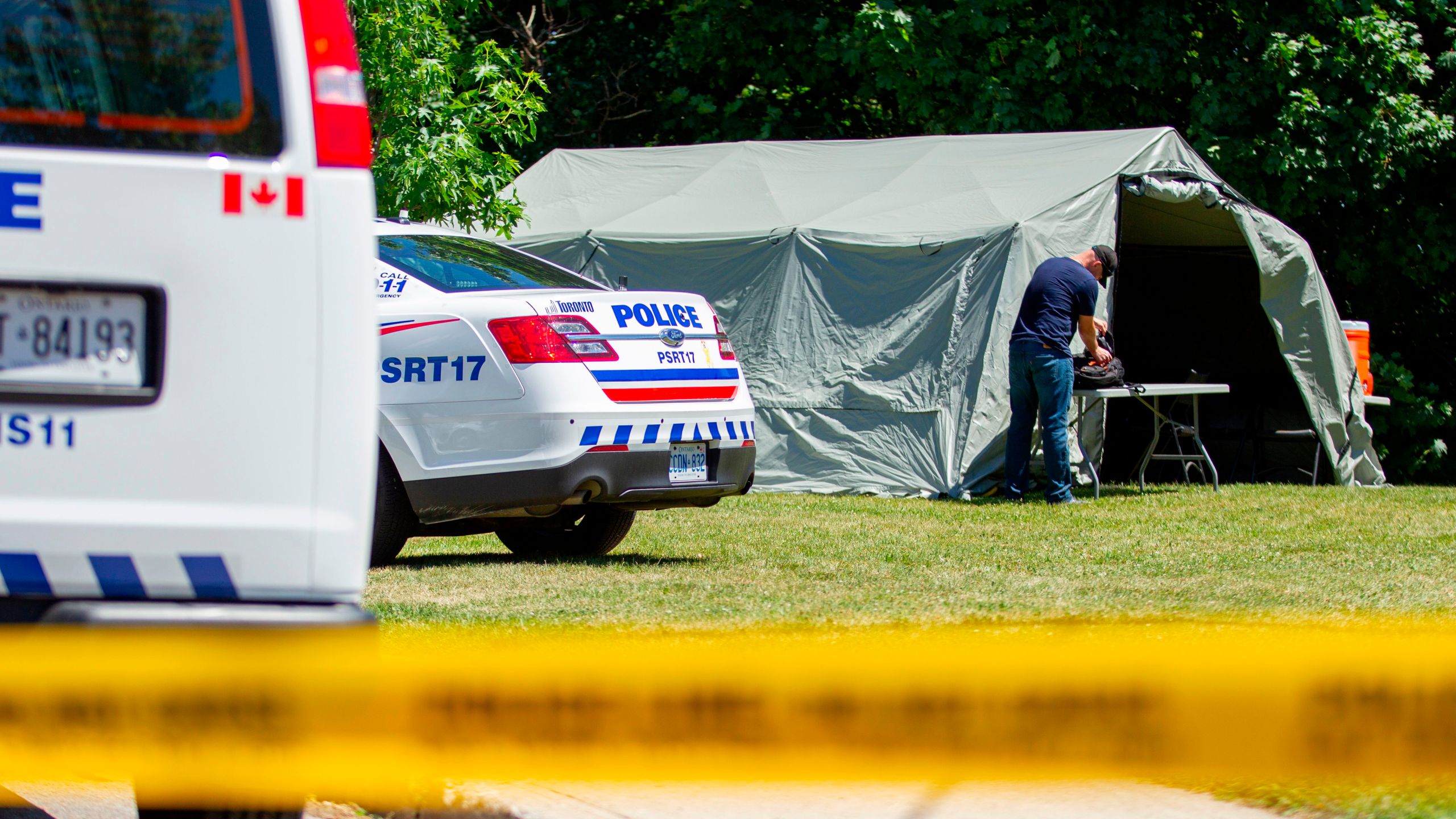 Investigators walk near a ravine behind a home on Mallory Crescent in Toronto, Ontario, July 6, 2018 where human remains were discovered in connection to the case of serial killer Bruce McArthur. (Credit: GEOFF ROBINS/AFP/Getty Images)