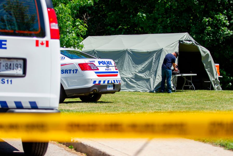 Investigators walk near a ravine behind a home on Mallory Crescent in Toronto, Ontario, July 6, 2018 where human remains were discovered in connection to the case of serial killer Bruce McArthur. (Credit: GEOFF ROBINS/AFP/Getty Images)