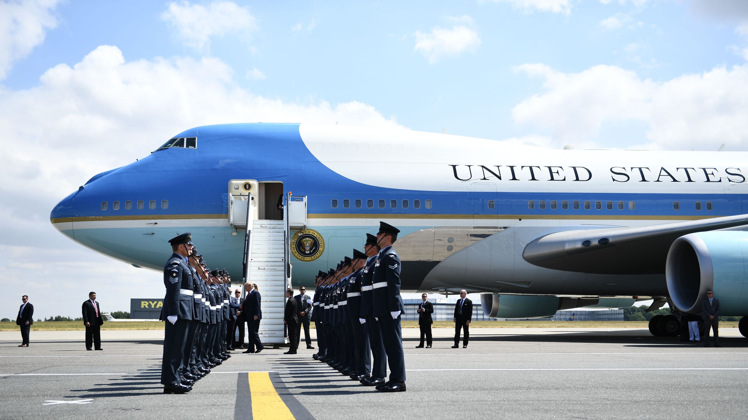 US President Donald Trump (C) and US First Lady Melania Trump are greeted by an honour guard of Royal Air Force personnel after disembarking Air Force One at Stansted Airport, north of London on July 12, 2018, as he begins his first visit to the UK as US president. (Credit: BRENDAN SMIALOWSKI/AFP/Getty Images)