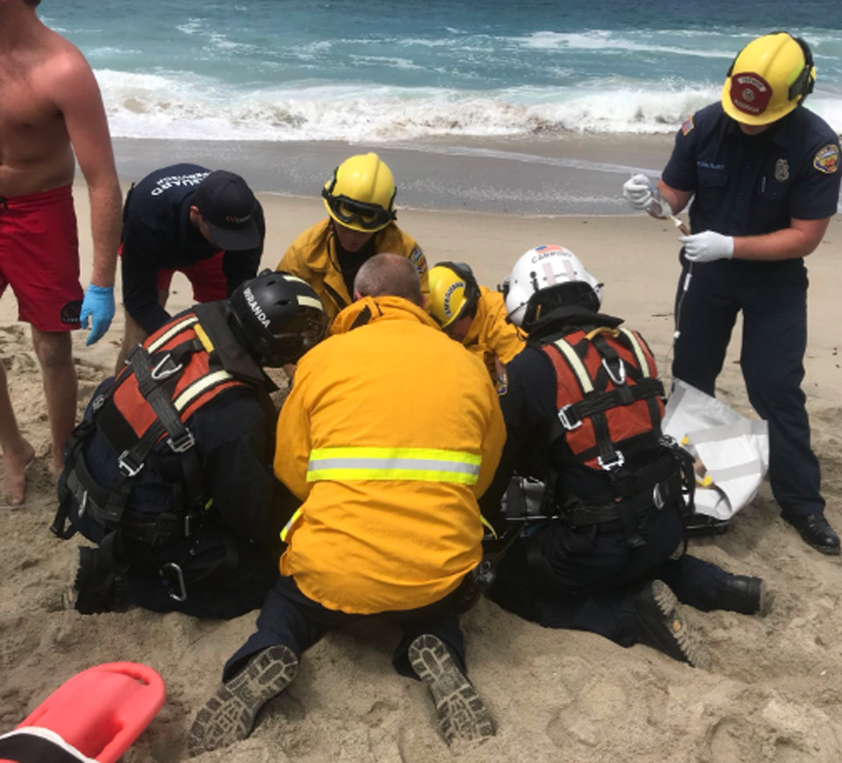 Authorities are shown trying to help a swimmer on July 14, 2018 at 1000 Steps Beach in Laguna Beach. (Credit: Laguna Beach Police Department Public Information Officer Sgt. Jim Cota's Twitter Account).