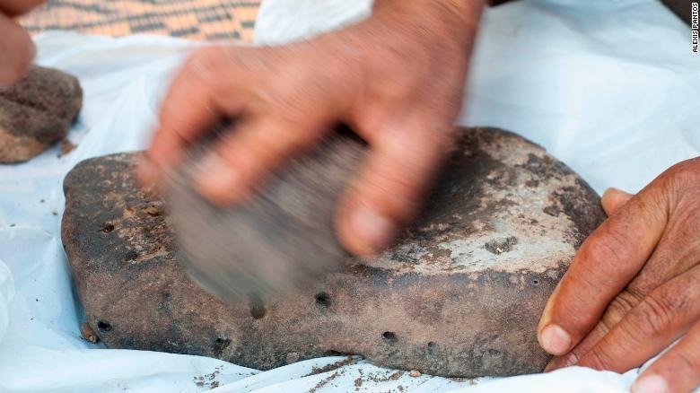 An archeologist grinds club rush for the experimental production of flour. (Credit: Alexis Pantos)