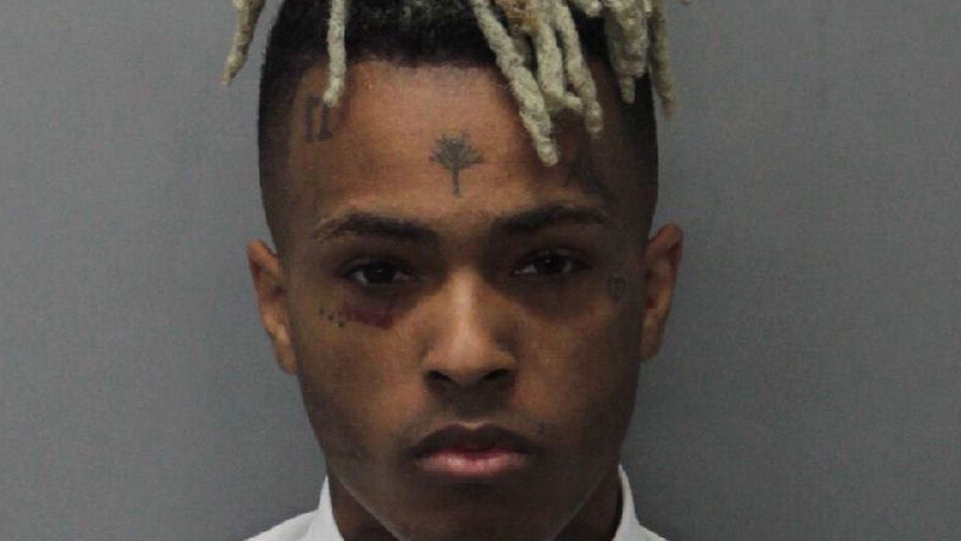 In this handout provided by the Miami Dade County Corrections, Rapper XXXTentacion, also known as Jahseh Dwayne Onfroy, poses for his mugshot after being charged with seven new felonies stemming from a 2016 domestic violence case on December 15, 2017, in Miami, Fla. (Credit: Miami Dade County Corrections via Getty Images)