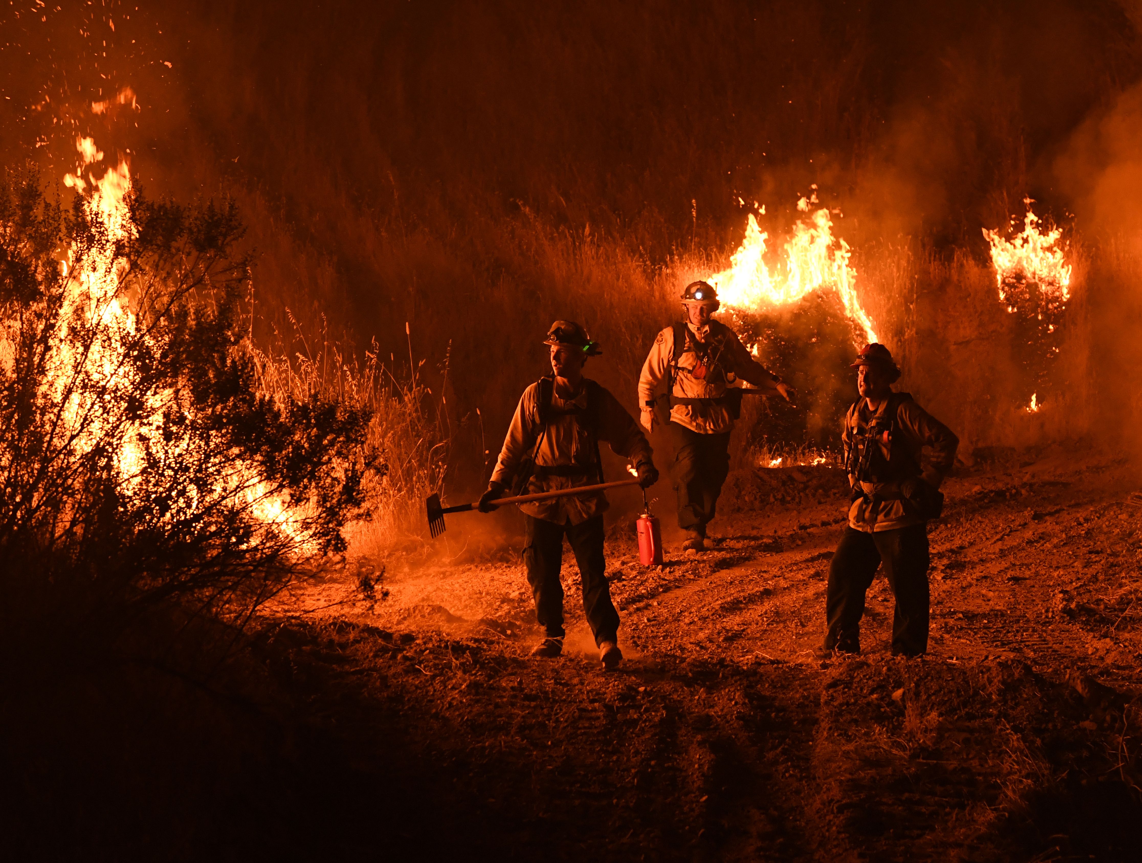 Firefighters conduct a controlled burn to defend houses against flames from the Ranch Fire, part of the Mendocino Complex Fire, as it continues to spreads toward the town of Upper Lake on Aug. 2, 2018. (Credit: Mark Ralston / AFP / Getty Images)