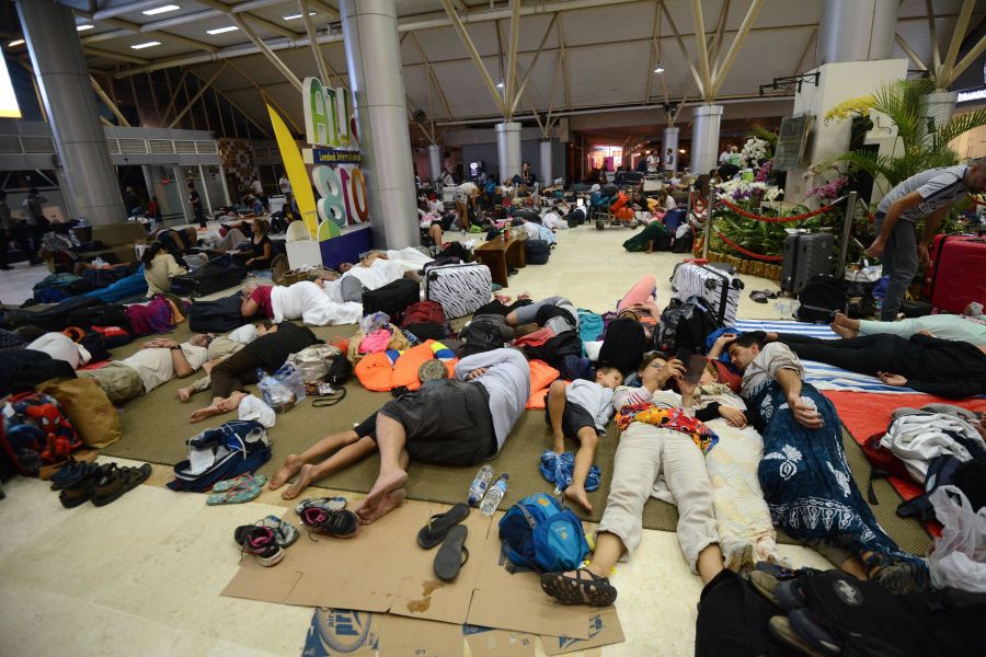 Tourists sleep while waiting to depart from the Praya Lombok International Airport on the West Nusa Tenggara province on Aug. 6, 2018. (Credit: SONNY TUMBELAKA/AFP/Getty Images)