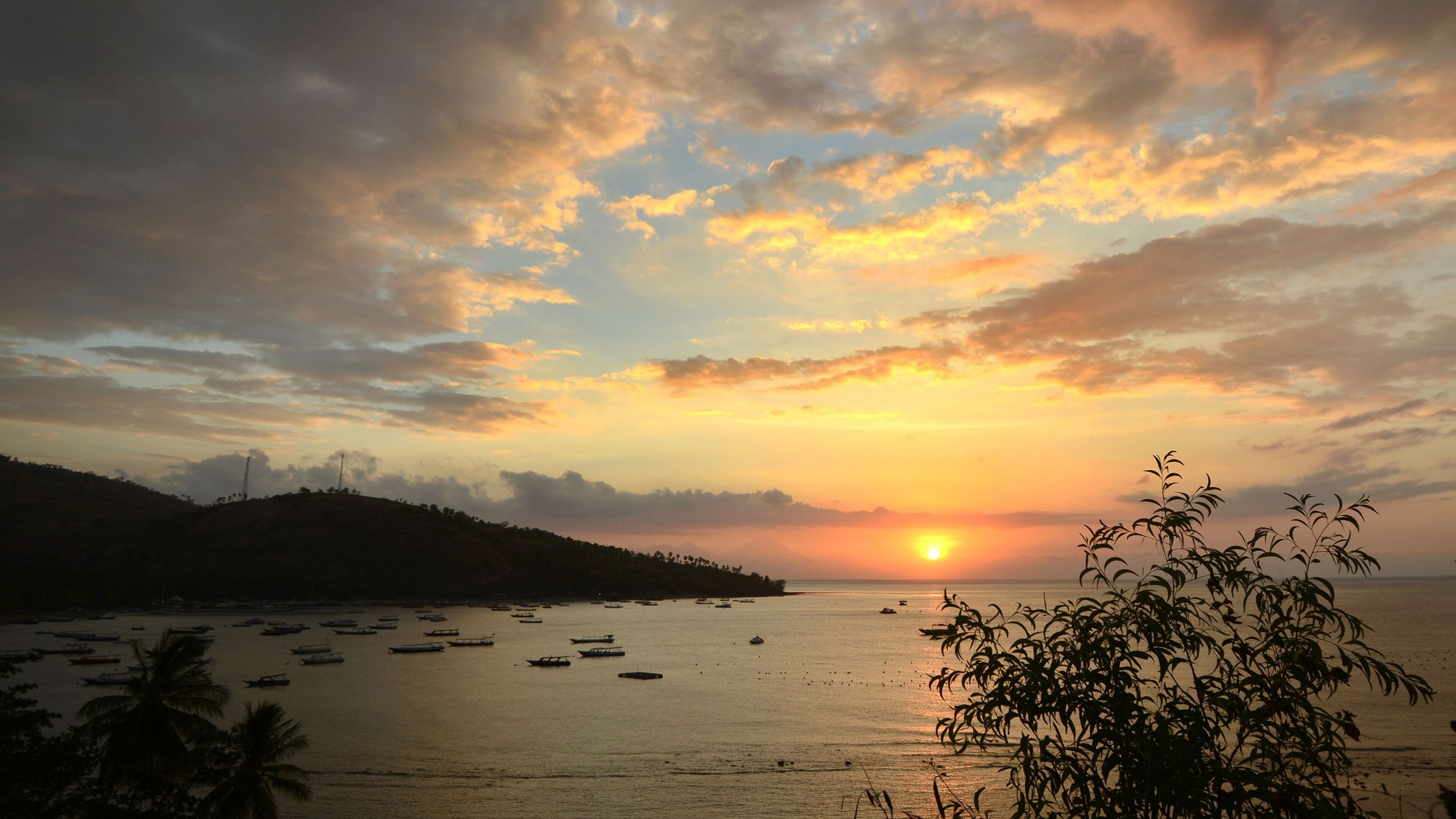 This picture taken on Aug. 9, 2018 shows tourist rental boats moored as the sun set after the recent quakes at Teluk Nare port in Pemenang in northern Lombok island. (Credit: SONNY TUMBELAKA/AFP/Getty Images)