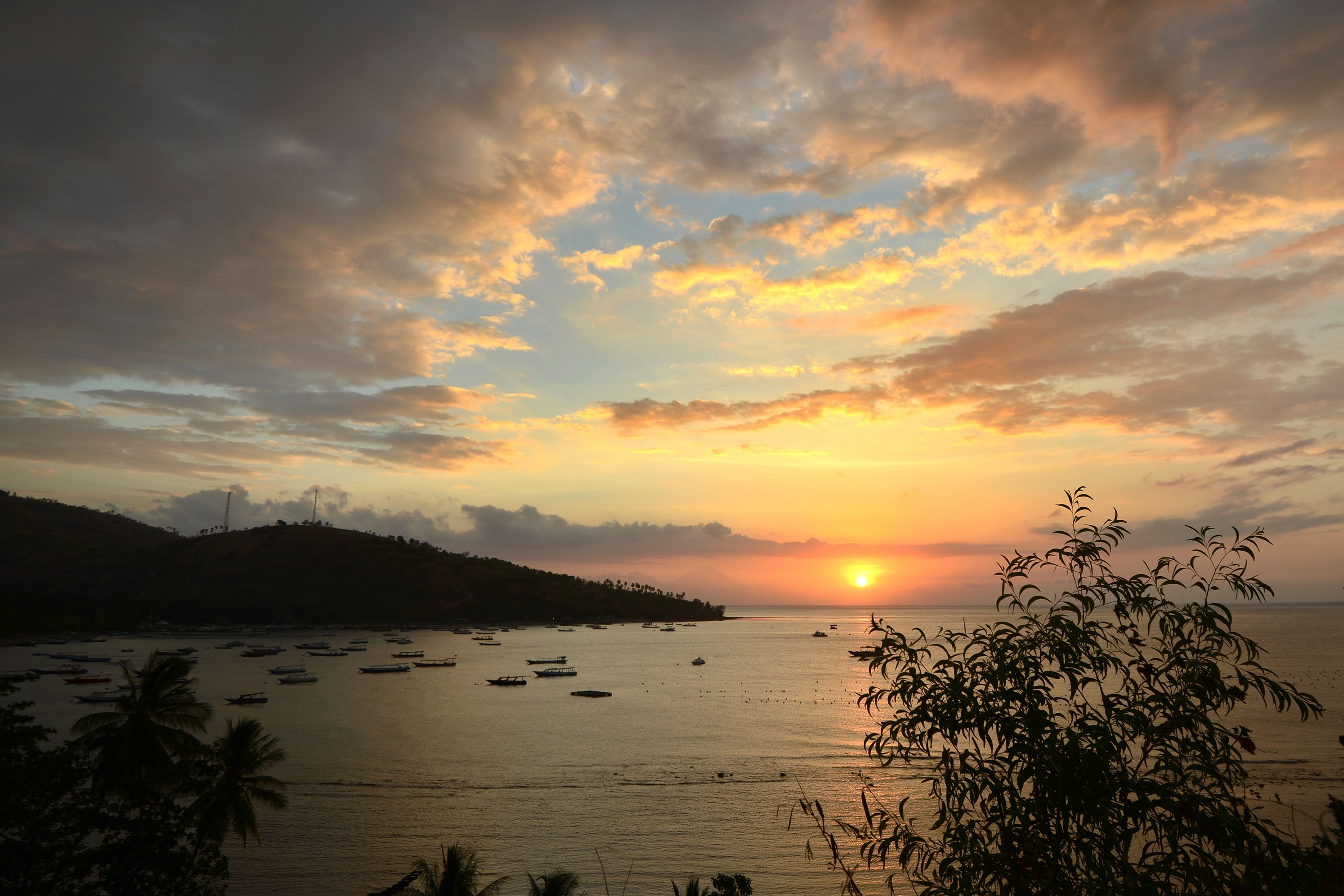 This picture taken on Aug. 9, 2018 shows tourist rental boats moored as the sun set after the recent quakes at Teluk Nare port in Pemenang in northern Lombok island. (Credit: SONNY TUMBELAKA/AFP/Getty Images)