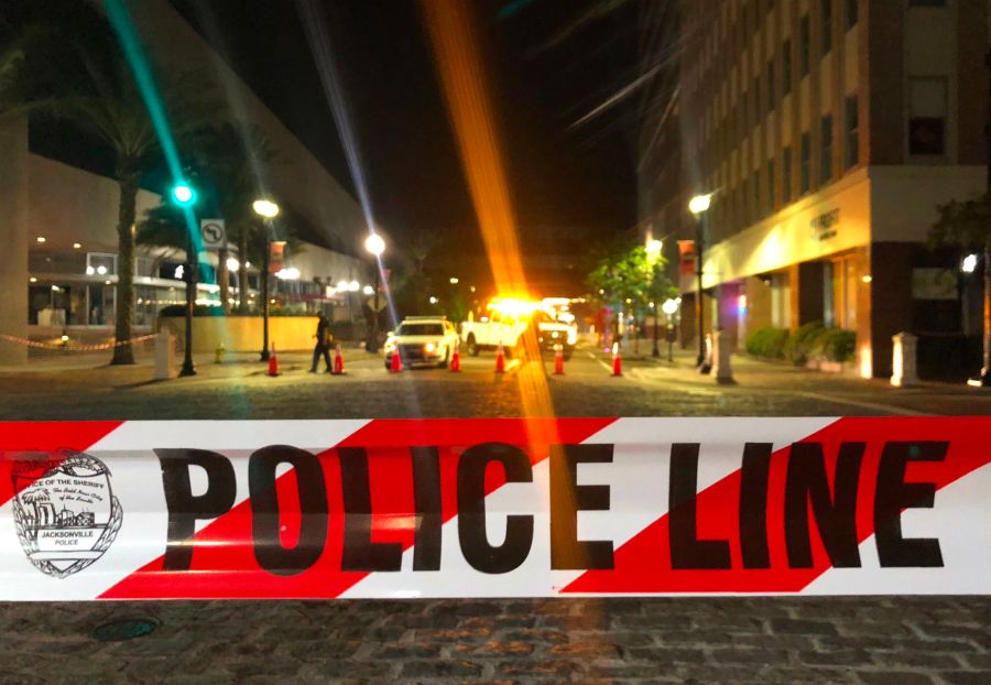 A patrol car is seen behind police tape blocking a street leading to the Jacksonville Landing area in downtown Jacksonville, Florida, on Aug. 26, 2018. (Credit: GIANRIGO MARLETTA/AFP/Getty Images)