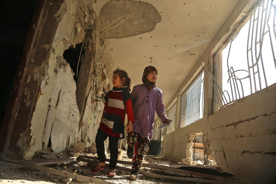 Syrian children tour their damaged school on Nov. 9, 2017, in the besieged rebel-held Eastern Ghouta town of Saqba, on the outskirts of the Syrian capital Damascus, following air raids by government forces on the area the previous day. (Credit: AMER ALMOHIBANY/AFP/Getty Images)