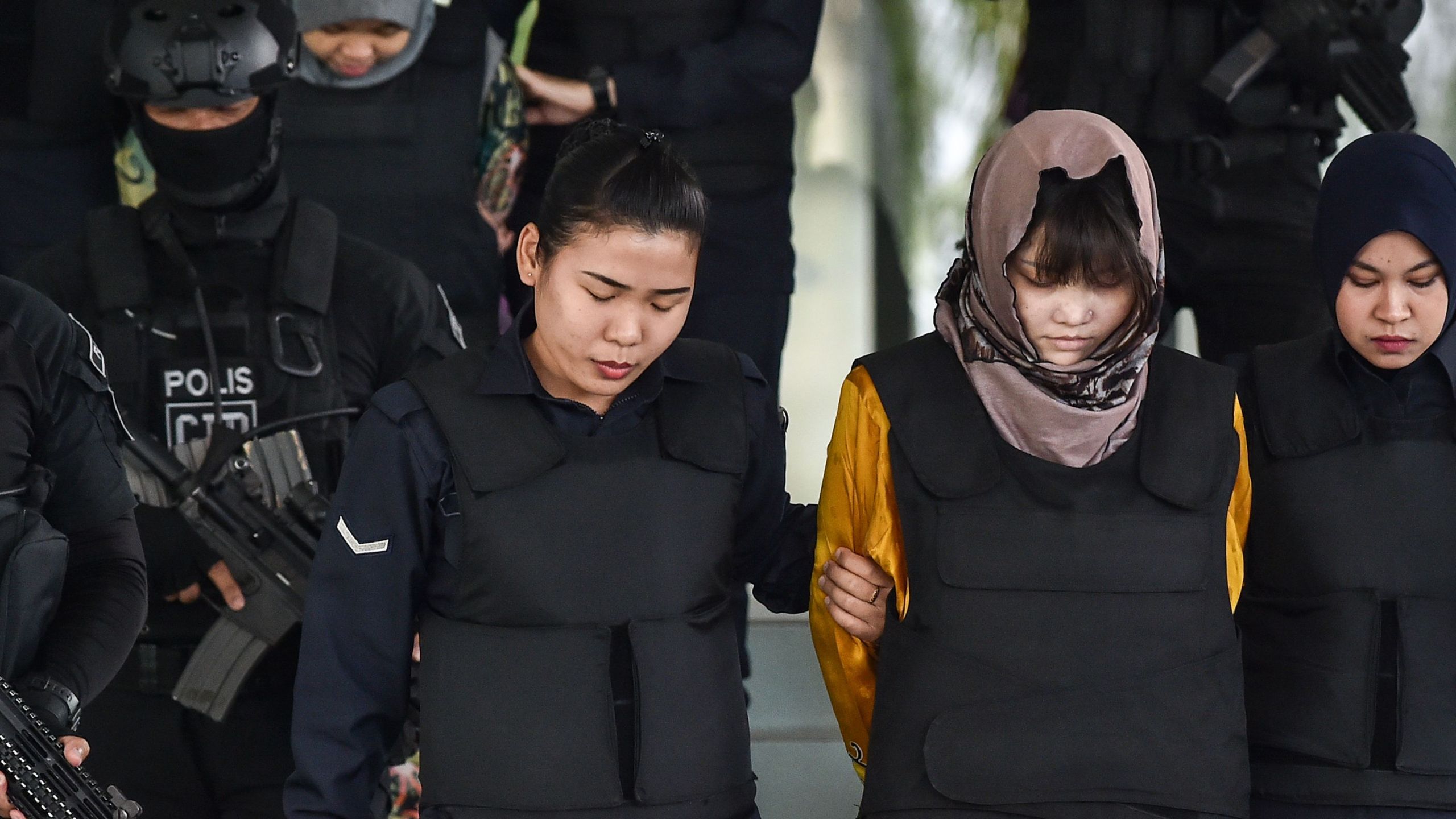 Vietnamese national Doan Thi Huong (front, second from right) and Indonesian national Siti Aisyah (back, second from left) are escorted by Malaysian police after a court session for their trial for their alleged roles in the assassination of Kim Jong Nam at the Shah Alam High Court, outside Kuala Lumpur, on June 27, 2018. (Credit: Mohd Rasfan / AFP / Getty Images)