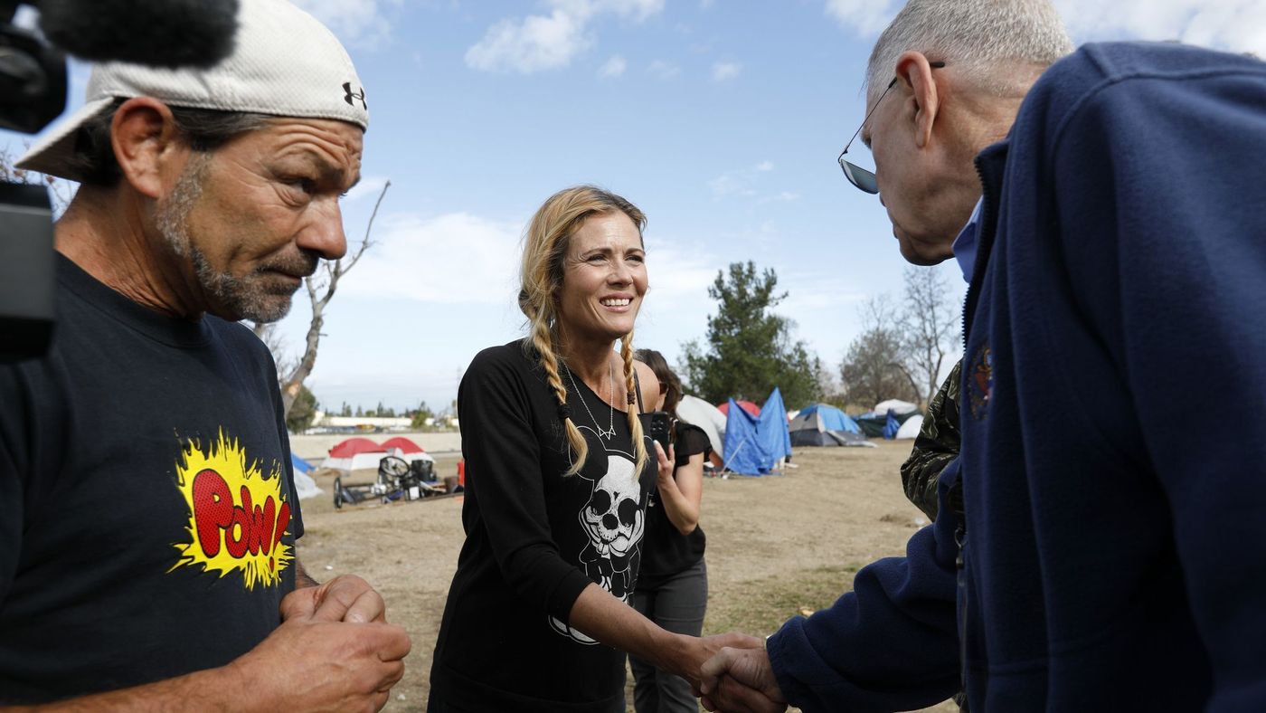 U.S. District Judge David Carter, right, greets homeless residents Frank Fabozzi, 56, and Amy Potter, 47, while surveying the homeless encampment along the Santa Ana River in Anaheim in February 2018. (Credit: Gary Coronado / Los Angeles Times)