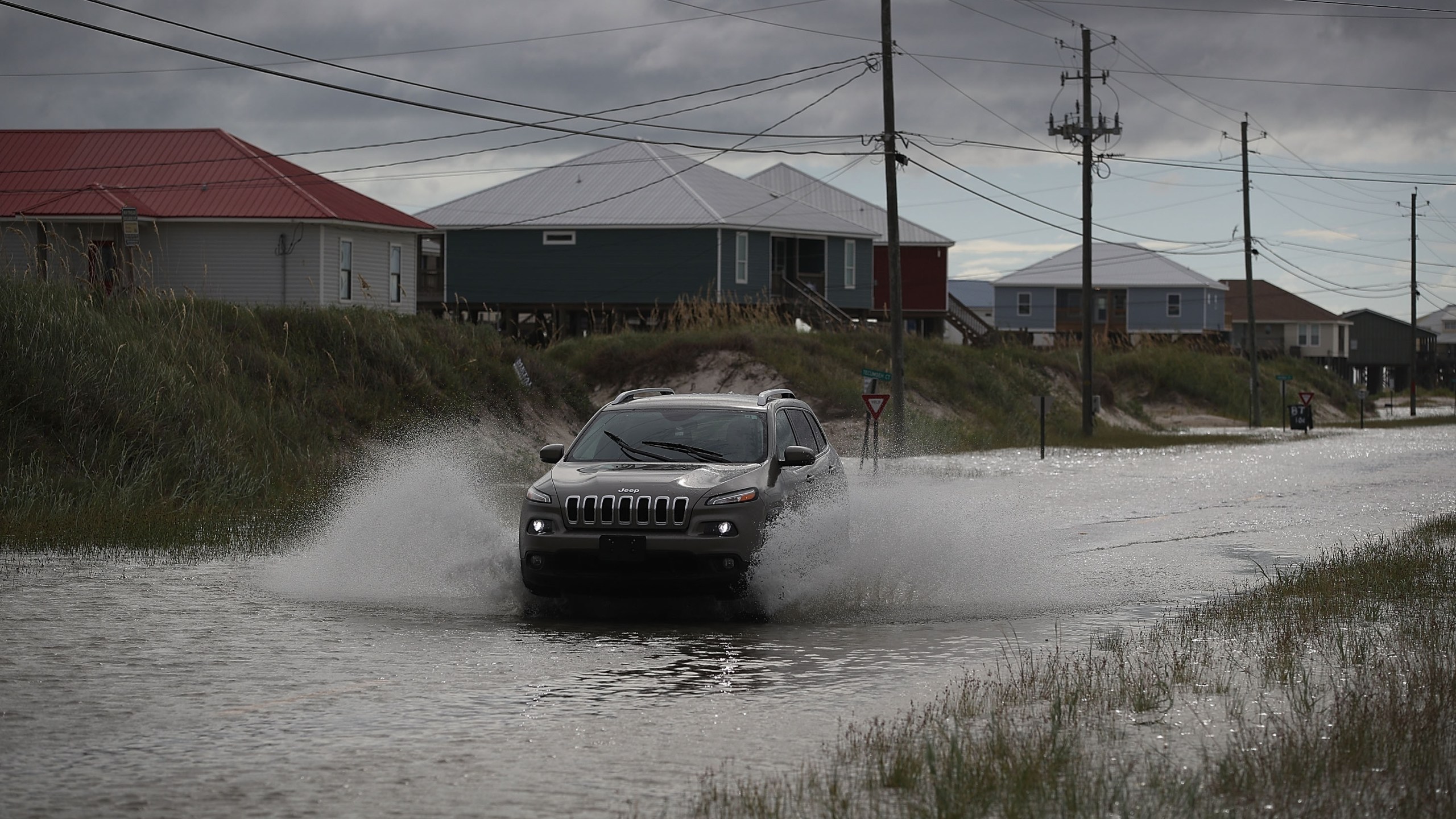 A vehicle drives along a flooded street caused by the approaching Tropical Storm Gordon on September 4, 2018 in Dauphin Island, Alabama. (Credit: Joe Raedle/Getty Images)