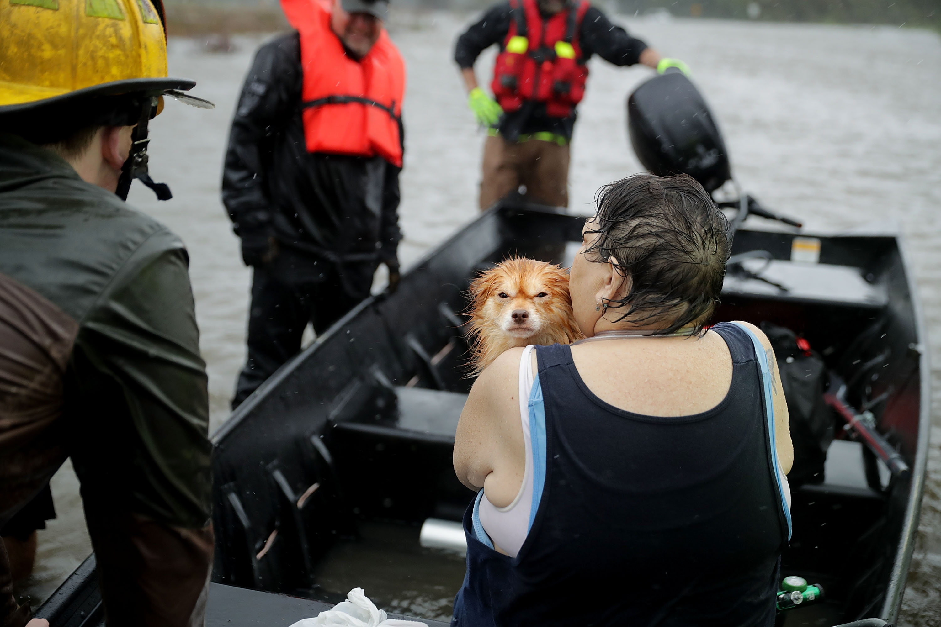 Rescue workers from Township No. 7 Fire Department and volunteers from the Civilian Crisis Response Team use a boat to rescue a woman and her dog from their flooded home during Hurricane Florence September 14, 2018 in James City, North Carolina. (Credit: Chip Somodevilla/Getty Images)