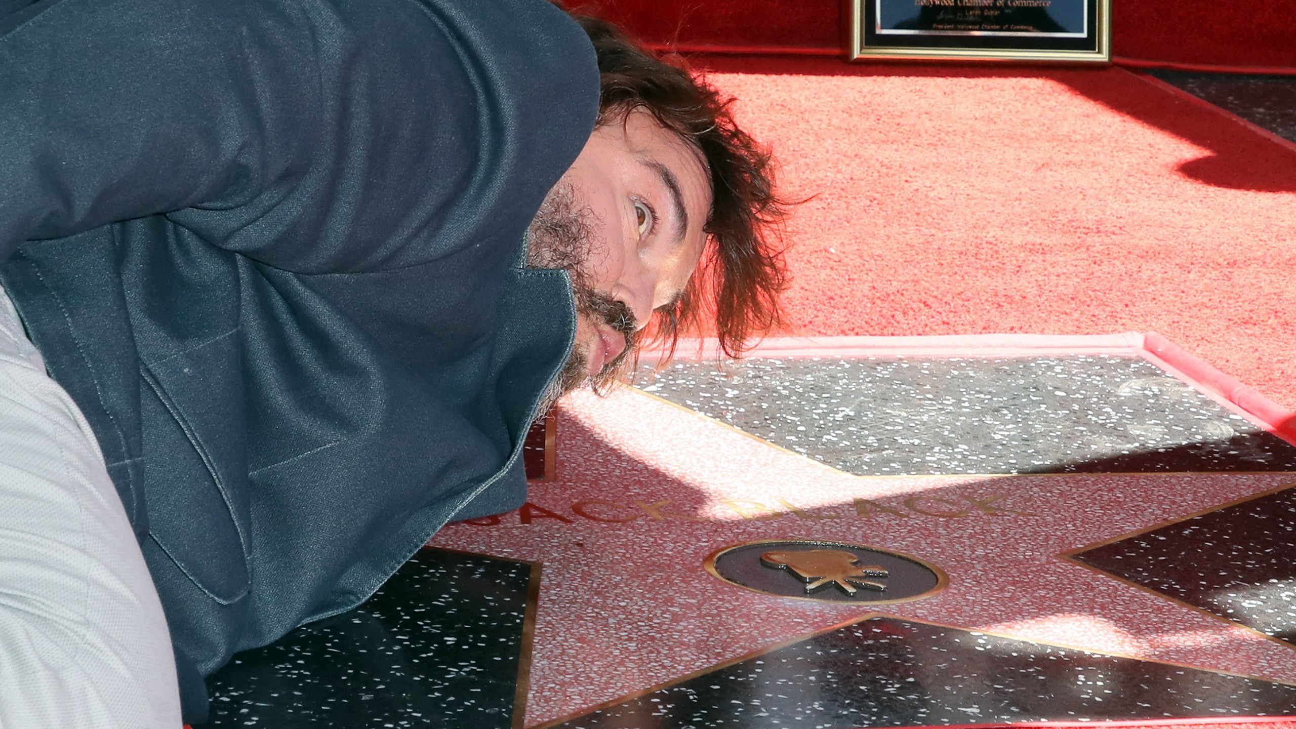 Jack Black pretends to kiss his newly-minted star on the Hollywood Walk of Fame on Sept. 18, 2018. (Credit: David Livingston/Getty Images)