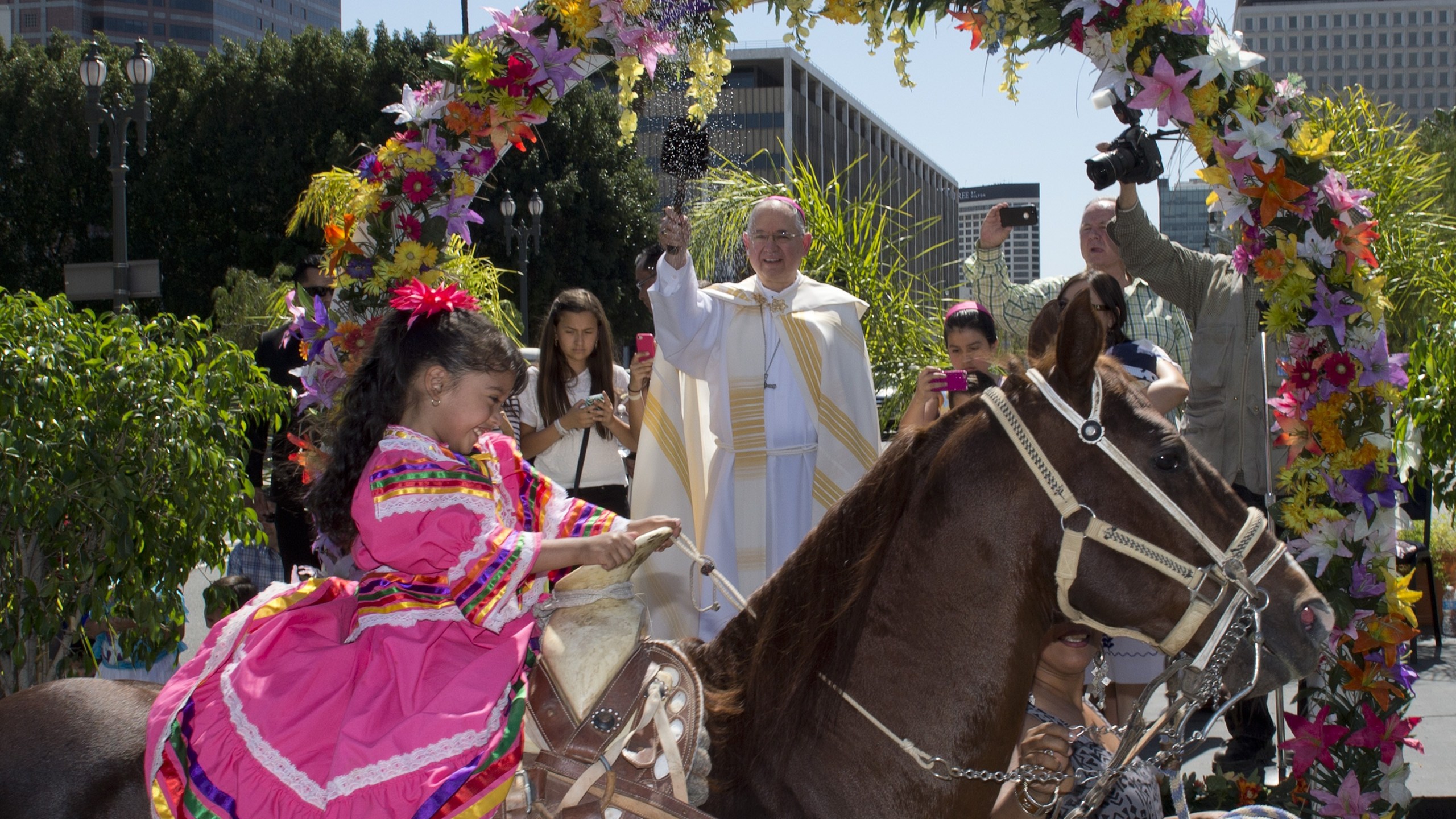 Anaii Gutierrez,4, and her horse Cara de Chango receive a holy water blessing from Catholic Archbishop Jose H. Gomez during a Blessing of Animals Easter event in Los Angeles on April 4, 2015. (Credit: MARK RALSTON/AFP/Getty Images)