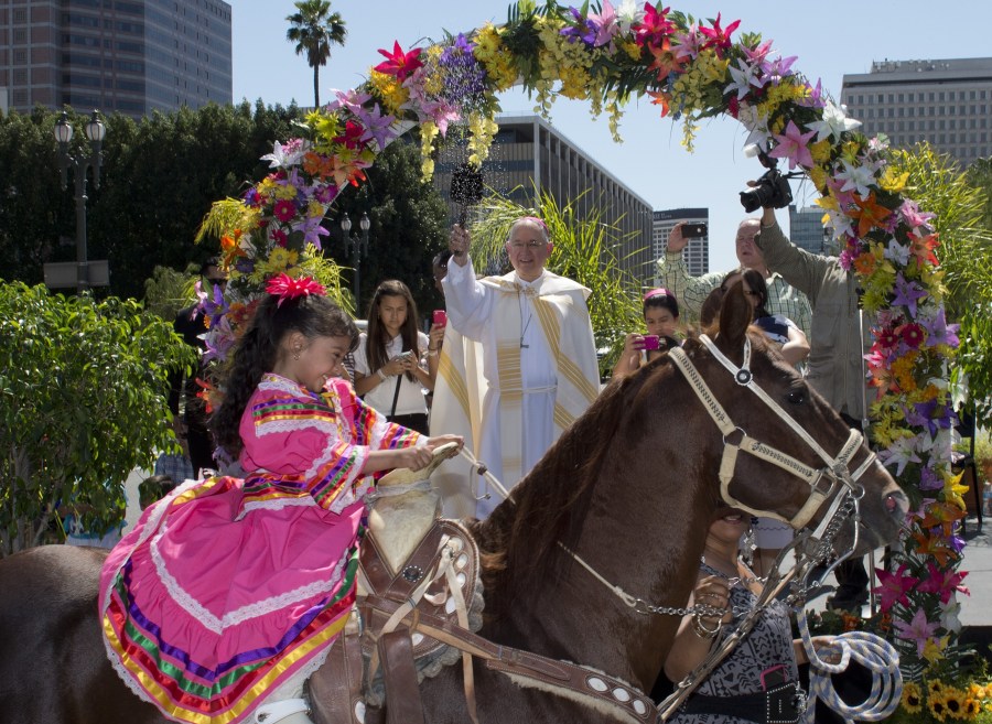 Anaii Gutierrez,4, and her horse Cara de Chango receive a holy water blessing from Catholic Archbishop Jose H. Gomez during a Blessing of Animals Easter event in Los Angeles on April 4, 2015. (Credit: MARK RALSTON/AFP/Getty Images)