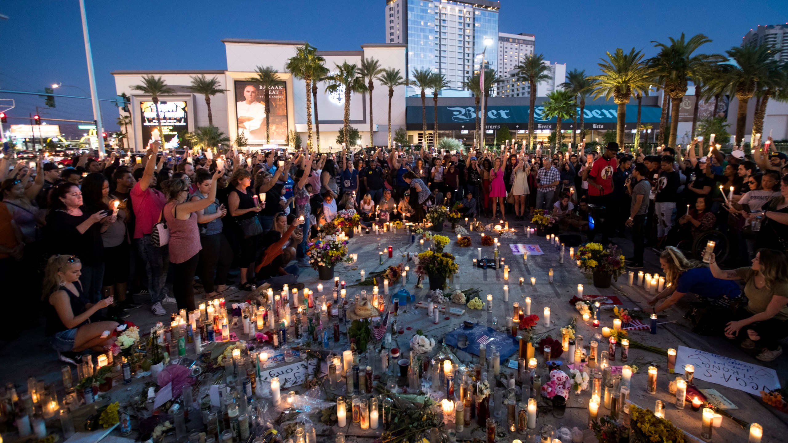 Mourners hold their candles in the air during a moment of silence during a vigil to mark one week since the mass shooting at the Route 91 Harvest country music festival, on the corner of Sahara Avenue and Las Vegas Boulevard at the north end of the Las Vegas Strip, on Oct. 8, 2017, in Las Vegas. (Credit: Drew Angerer/Getty Images)