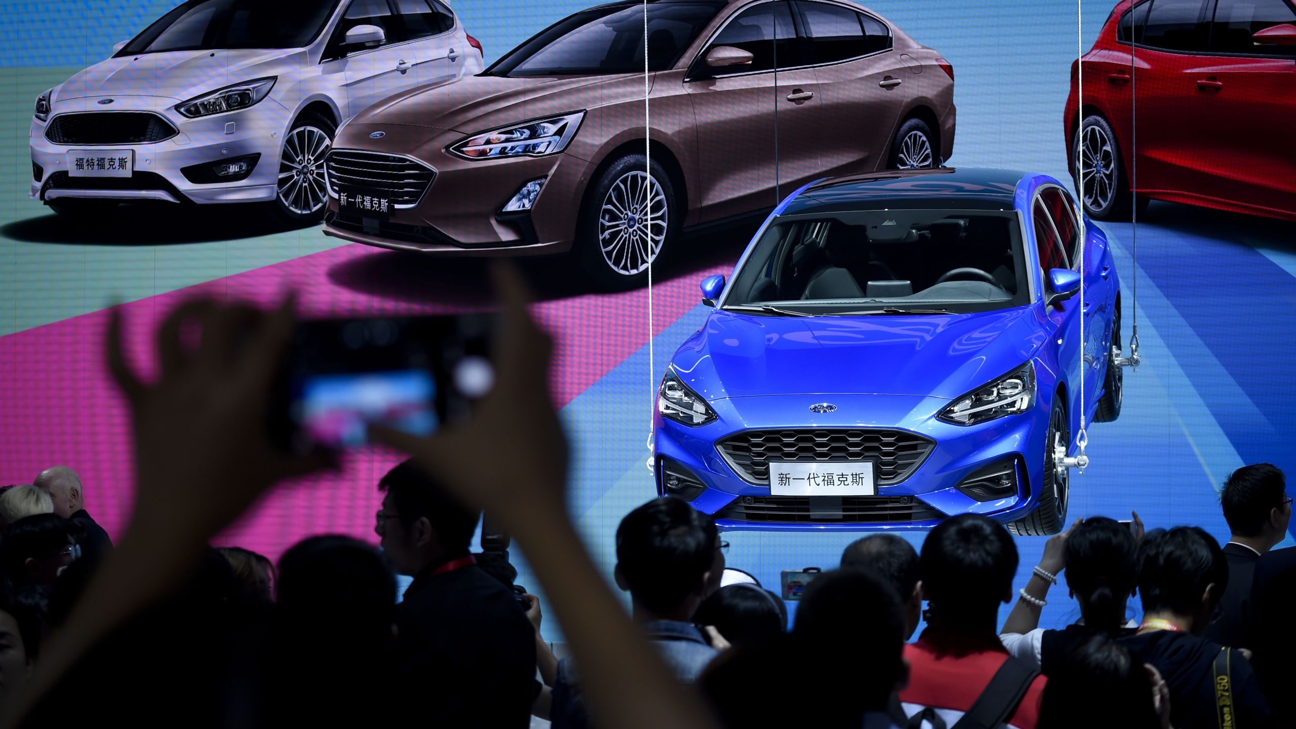 Visitors look at a display for the new Ford Focus at the Beijing auto show in Beijing on April 25, 2018. (Credit: WANG ZHAO/AFP/Getty Images)