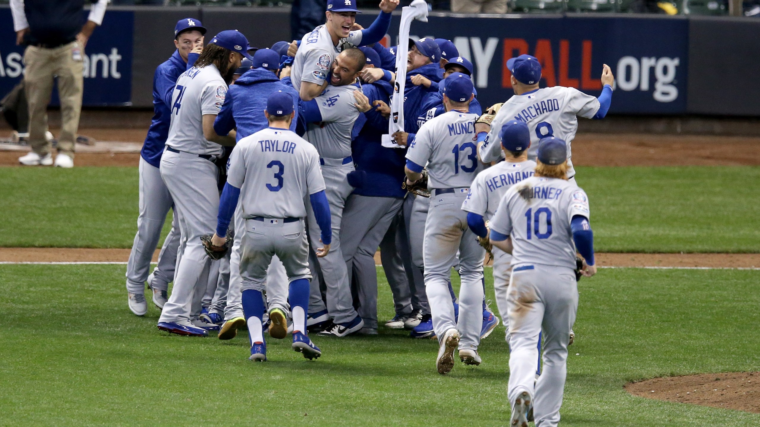 The Los Angeles Dodgers celebrate after defeating the Milwaukee Brewers in Game Seven to win the National League Championship Series at Miller Park on October 20, 2018 in Milwaukee, Wisconsin. (Credit: Dylan Buell/Getty Images)