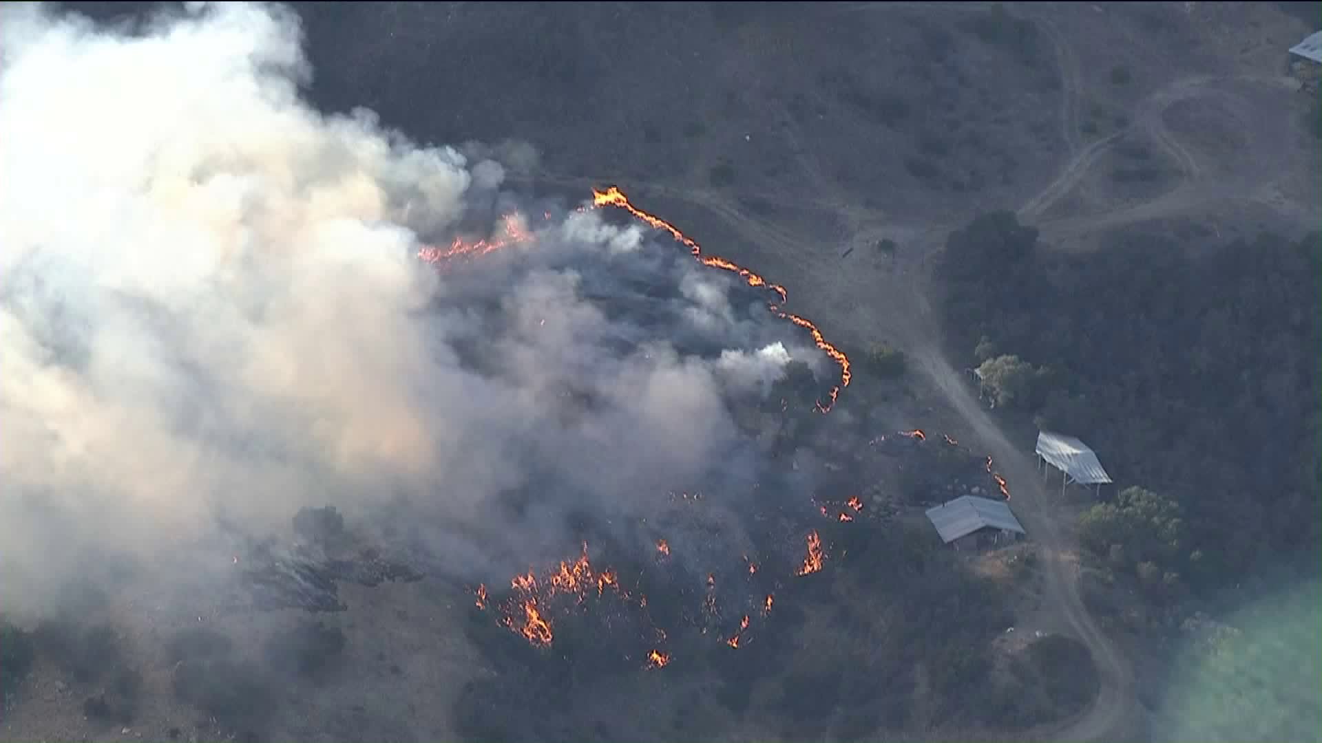 Firefighters battle a brush fire along Topanga Canyon Boulevard in the Topanga area on Oct. 31, 2018.