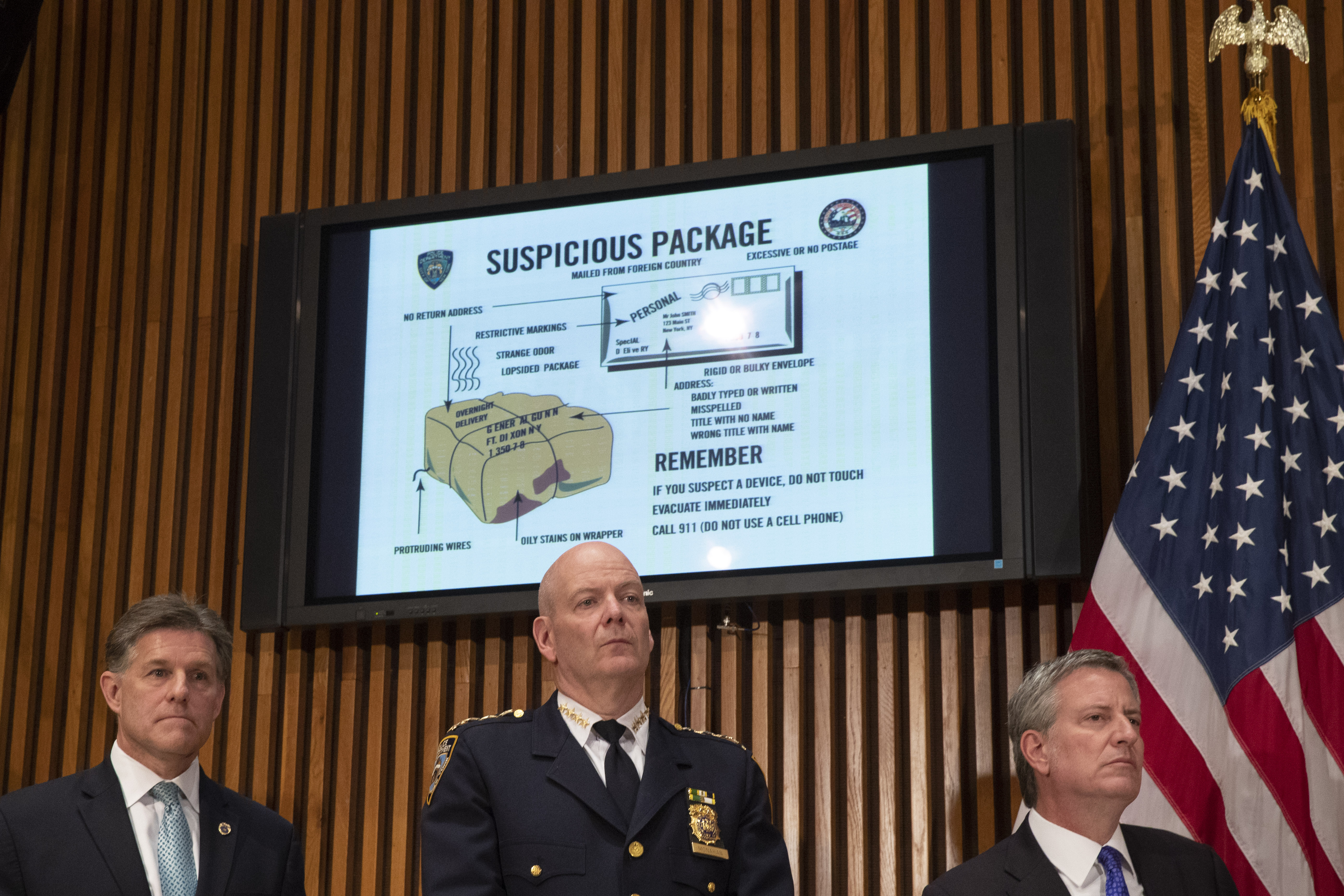 A monitor displays information about suspicious packages as NYPD Chief of Department Terence Monahan, center, and New York City Mayor Bill de Blasio, right, look on during a press conference at NYPD headquarters regarding the recent package bombings, Oct. 25, 2018. (Credit: Drew Angerer / Getty Images)