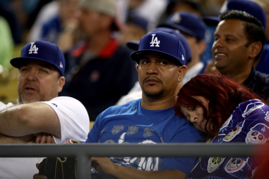 A fan rests during the 17th inning in Game 3 of the 2018 World Series between the Los Angeles Dodgers and the Boston Red Sox at Dodger Stadium on Oct. 26, 2018. (Credit: Ezra Shaw/Getty Images)