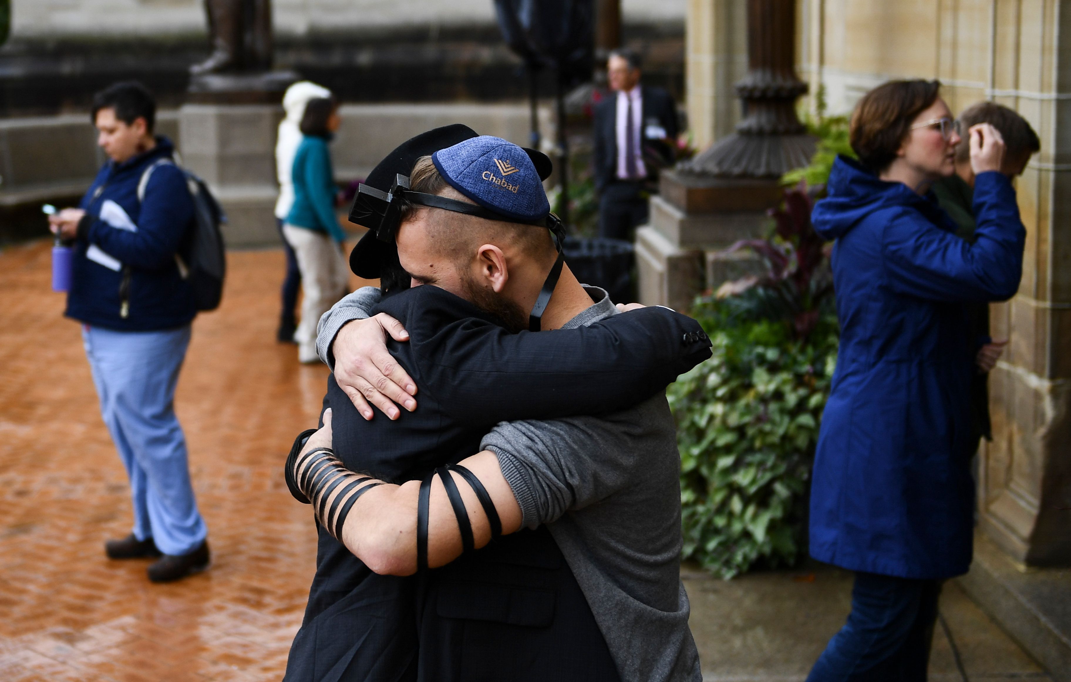 People hug as they arrive for a vigil following a mass shooting at the Tree of Life synagogue at the Allegheny County Soldiers Memorial on Oct. 28, 2018, in Pittsburgh, Pennsylvania.(Credit: BRENDAN SMIALOWSKI/AFP/Getty Images)