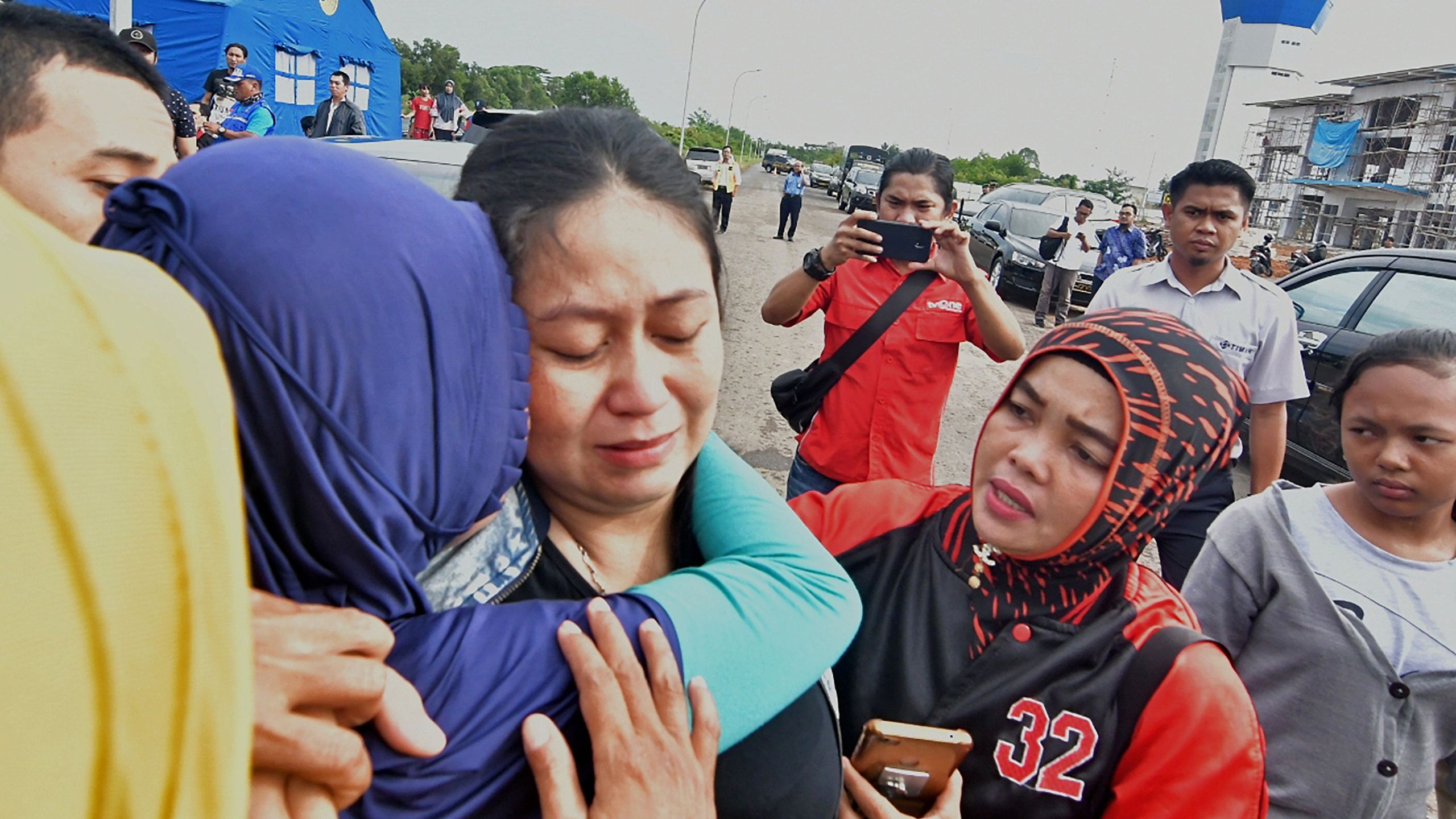 Putri (C), is consoled for the loss of her husband and child who were passengers on board the ill-fated Lion Air flight JT 610, in Pangkal Pinang airport in Bangka Belitung province on October 29, 2018. (Credit: RONI BAYU/AFP/Getty Images)