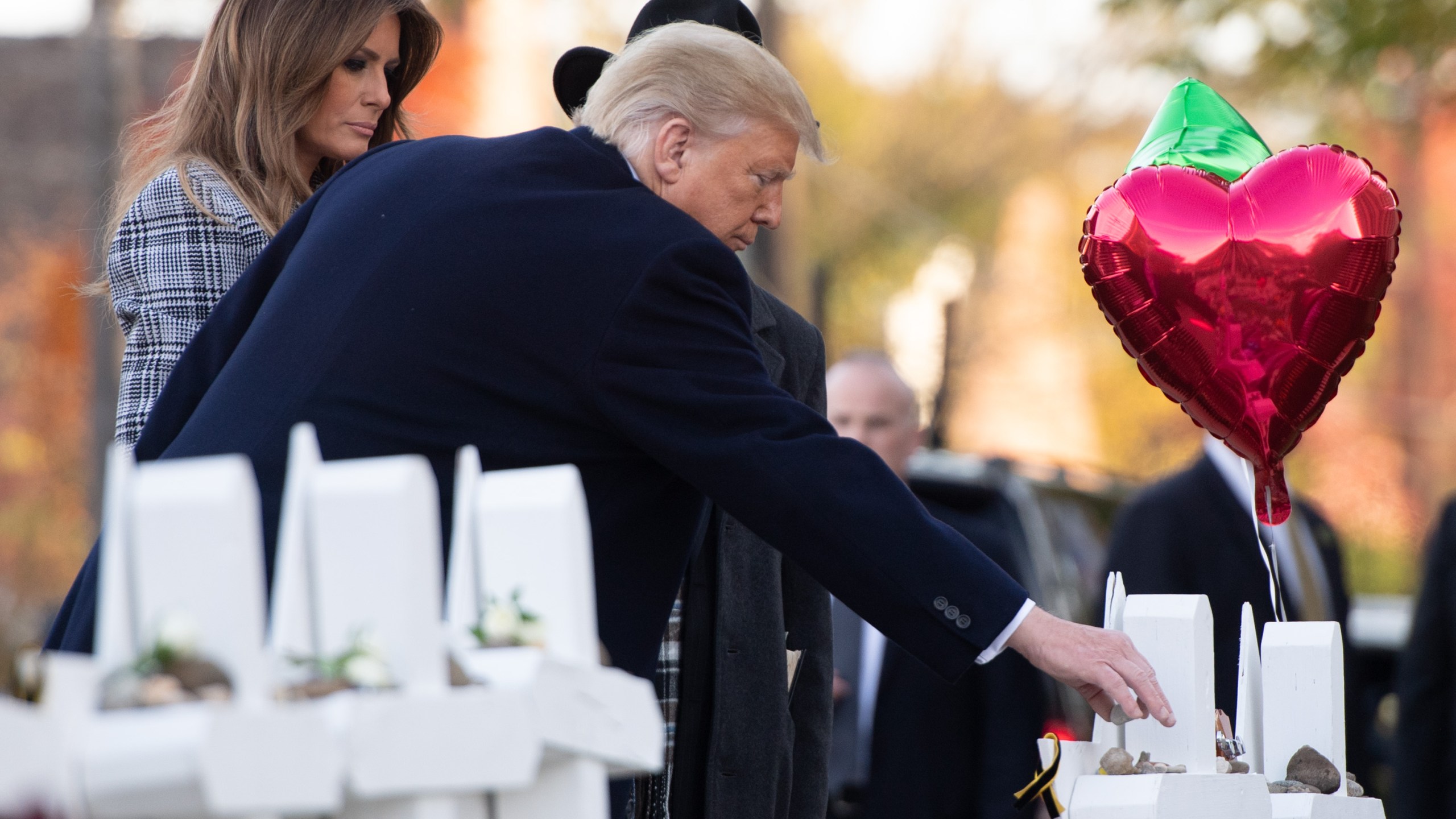 Donald Trump and First Lady Melania Trump, alongside Rabbi Jeffrey Myers, place stones and flowers on a memorial as they pay their respects at the Tree of Life Synagogue shooting victims in Pittsburgh on Oct. 30, 2018. (Credit: Saul Loeb/AFP/Getty Images)