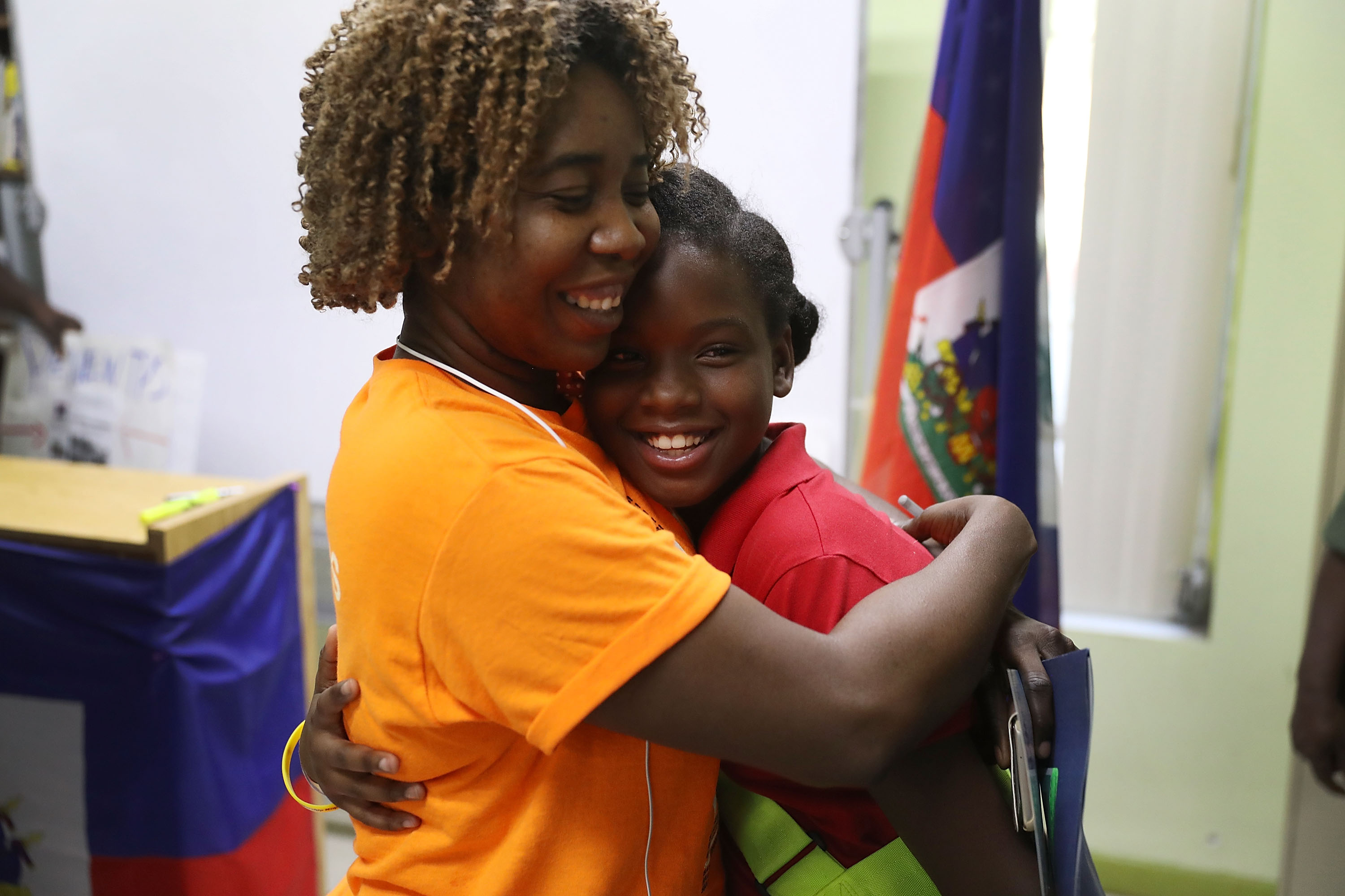 Santcha Etienne, left, hugs Ronyde Christina Ponthieux, 10, after she spoke about her father, originally from Haiti, who is here under Temporary Protective Status during a press conference on Nov. 6, 2017, in Miami, Florida. (Credit: Joe Raedle / Getty Images)