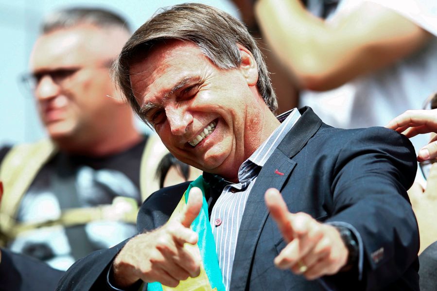 Jair Bolsonaro gives a thumbs up to supporters during a rally at Afonso Pena airport in Curitiba, Brazil on March 28, 2018. (Credit: HEULER ANDREY/AFP/Getty Images)