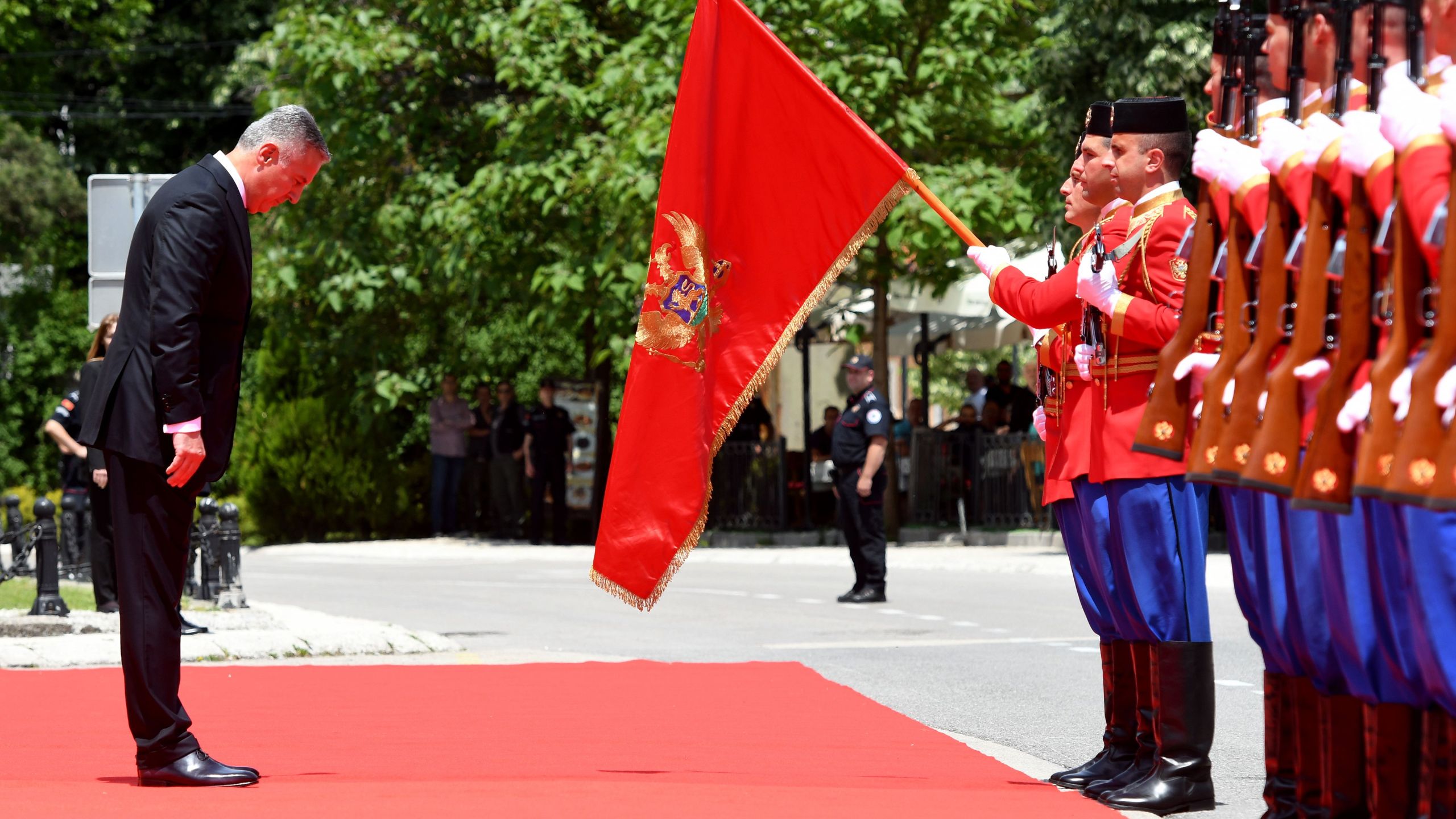 Six-time Prime Minister Milo Djukanovic bows in front of the national flag after he was sworn in as Montenegro's President in Cetinje on May 20, 2018. (Credit: SAVO PRELEVIC/AFP/Getty Images)