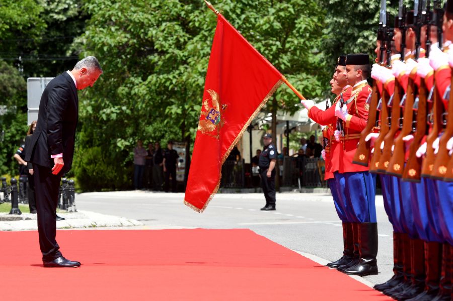 Six-time Prime Minister Milo Djukanovic bows in front of the national flag after he was sworn in as Montenegro's President in Cetinje on May 20, 2018. (Credit: SAVO PRELEVIC/AFP/Getty Images)