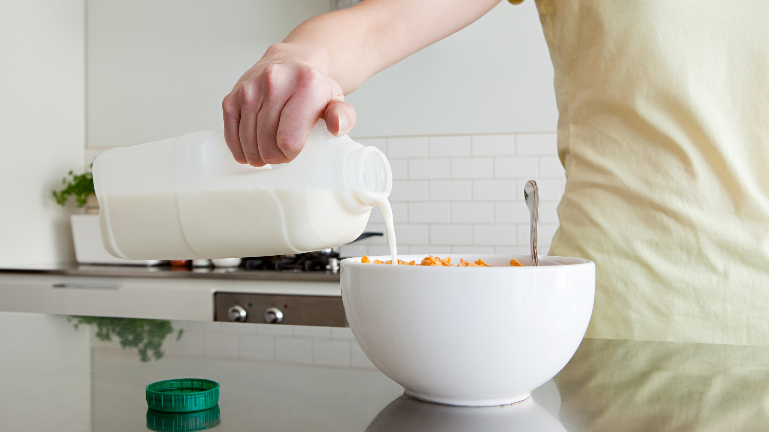 A woman is pouring milk onto cereal in this file photo. (Credit: Getty Images)