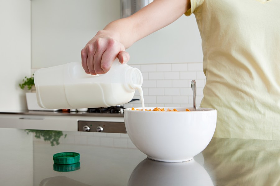 A woman is pouring milk onto cereal in this file photo. (Credit: Getty Images)