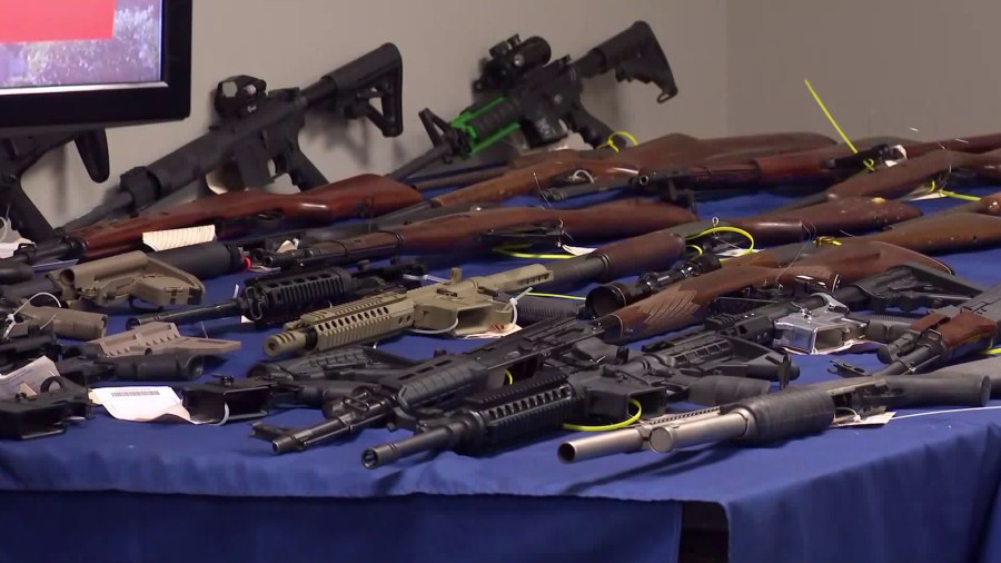 Authorities display 63 seized guns during a press conference to announce a major crackdown targeting gang members in Riverside County on Oct. 19, 2018.