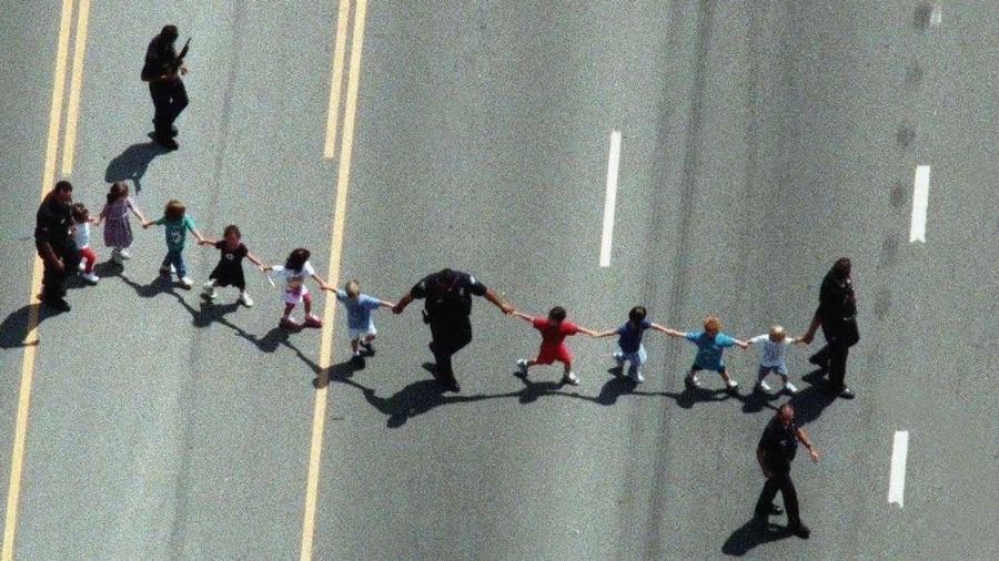 Children from the North Valley Jewish Community Center in Granada Hills are seen being escorted to safety by Los Angeles police officers after a gunman opened fire at the center on Aug. 10, 1999. (Credit: David Bohrer / Los Angeles Times)