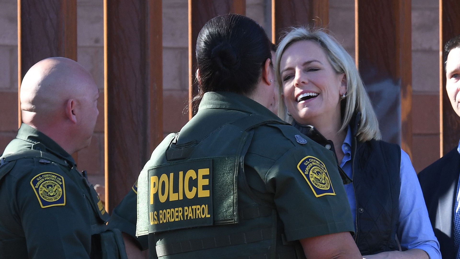 U.S. Department of Homeland Security Secretary Kirstjen M. Nielsen smiles alongside Border Patrol officer Gloria Chavez as they stand next to a plaque with President Trump's name on it at the first completed section of Trump's 30-foot border wall in the El Centro Sector, at the U.S. Mexico border in Calexico, Calif. on Oct. 26, 2018. (Credit: Mark RALSTON / AFP/ Getty Images)