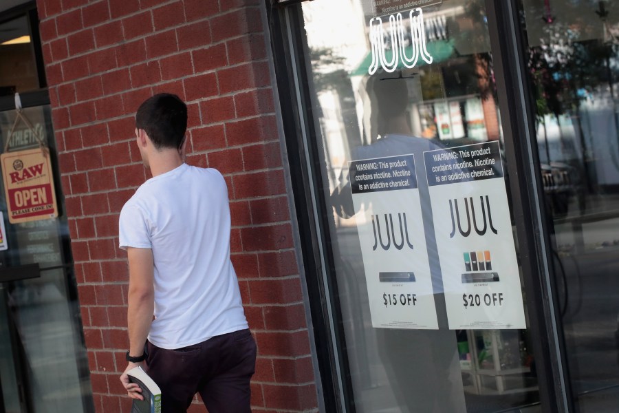 Signs in the window of the Smoke Depot in Chicago advertise electronic cigarettes and pods by Juul, the nation's largest maker of e-cigarette products, on Sept. 13, 2018. (Credit: Scott Olson/Getty Images)