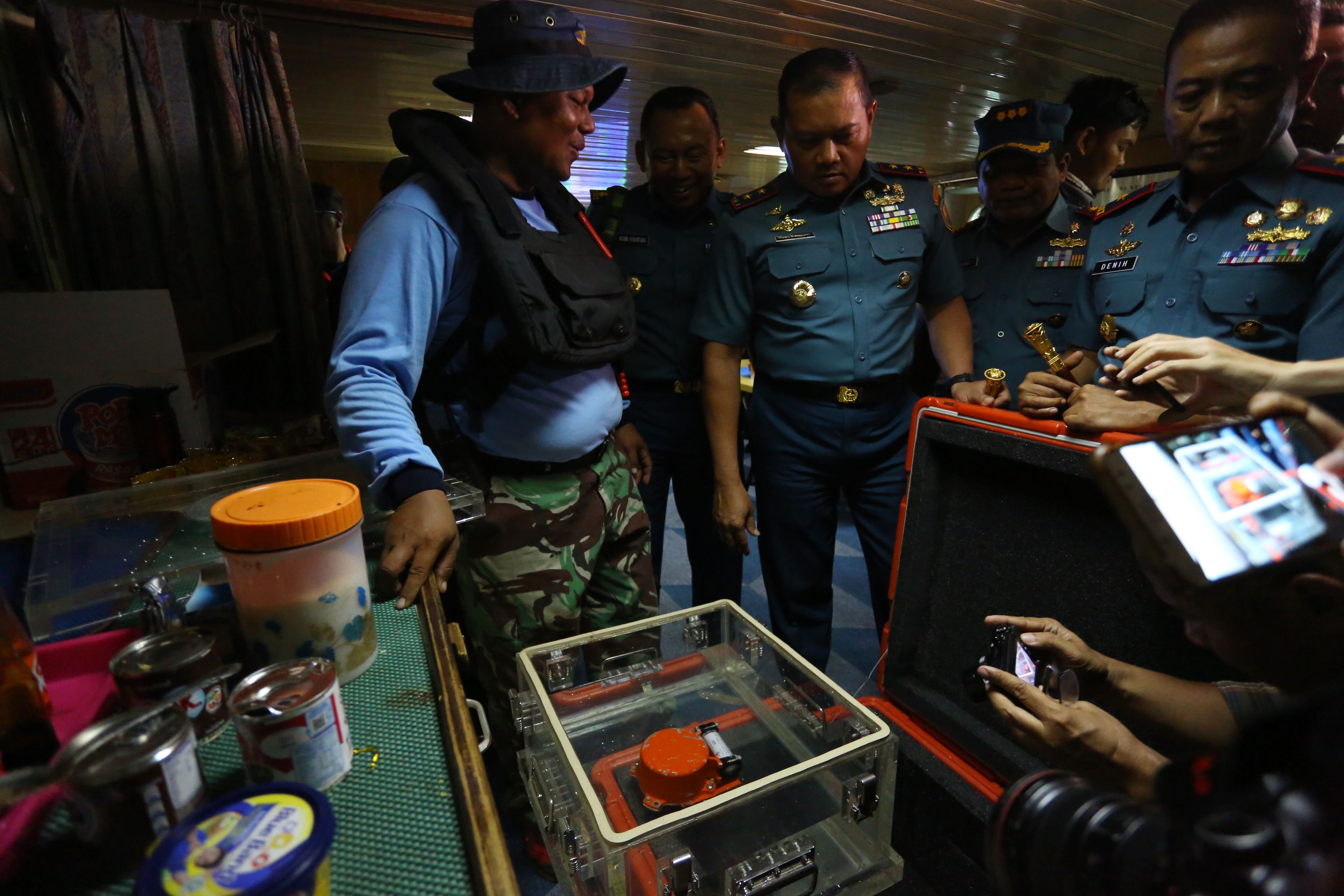 Officials look at the flight data recorder, part of the ill-fated Lion Air flight JT 610's black box, after it was recovered from the Java Sea during search operations in the waters off Karawang on Nov. (Credit: Malekiano/ AFP)