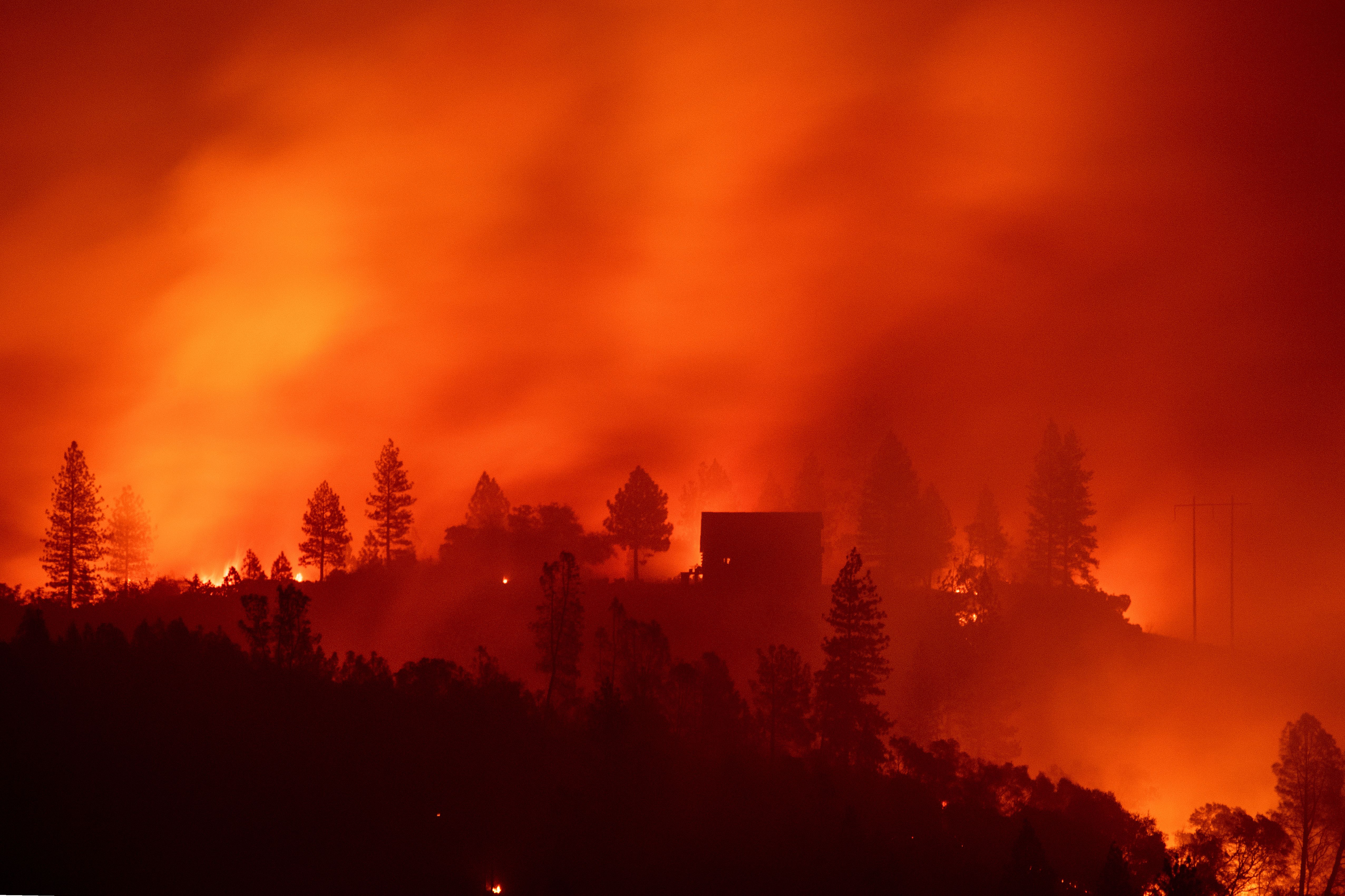 Flames from the Camp Fire burn near a home atop a ridge near Big Bend, California, on Nov. 10, 2018. (Credit: JOSH EDELSON/AFP/Getty Images)