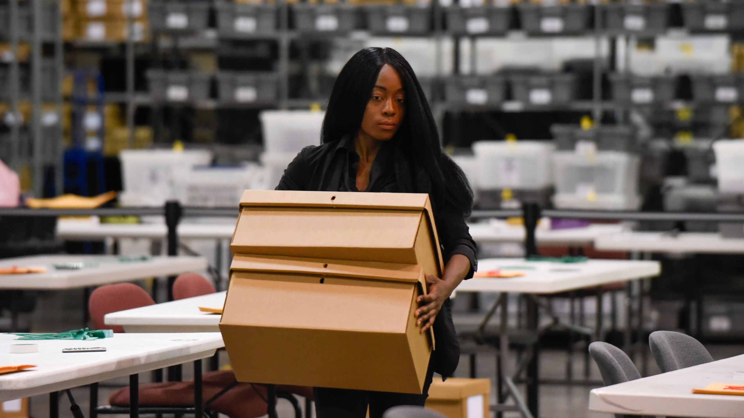 A woman sets up tables for hand counting ballots on November 15, 2018, as Palm Beach County did not meet the midterm recount deadline in West Palm Beach, Florida. (Credit: MICHELE EVE SANDBERG/AFP/Getty Images)