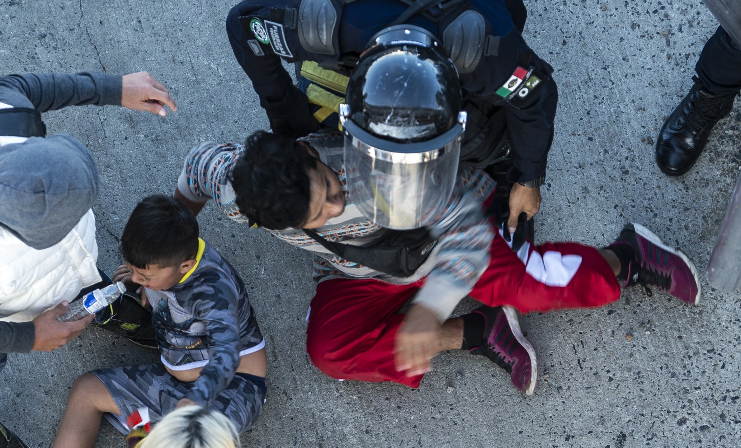 Central American migrants are stopped by Mexican police forces as they reach the El Chaparral border crossing, in Tijuana, Baja California State, Mexico, on Nov. 25, 2018. (Credit: PEDRO PARDO/AFP/Getty Images)