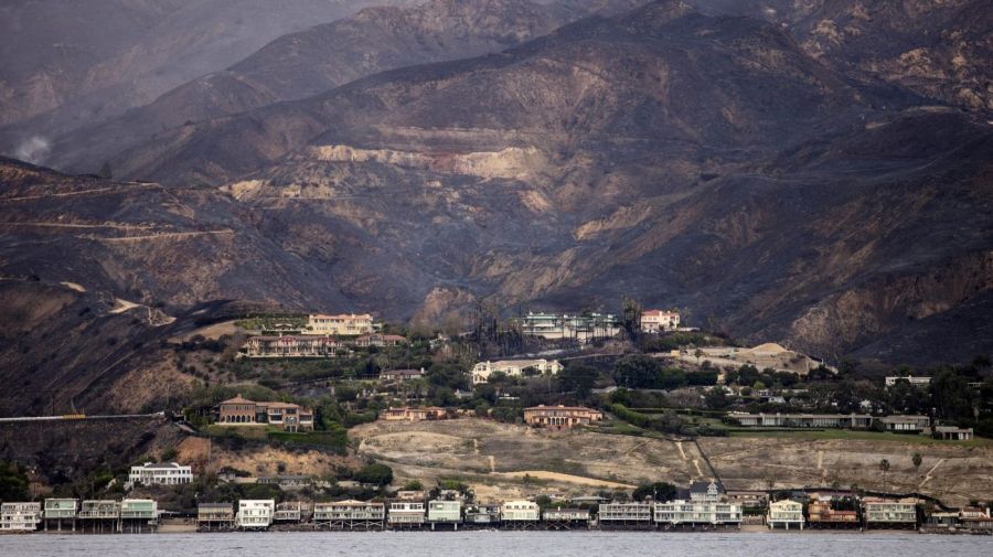 The charred Santa Monica Mountains rise behind homes in Malibu along Pacific Coast Highway, seen from a yacht that was bringing supplies to Paradise Cove on Nov. 13, 2018. (Credit: Jay L. Clendenin / Los Angeles Times)