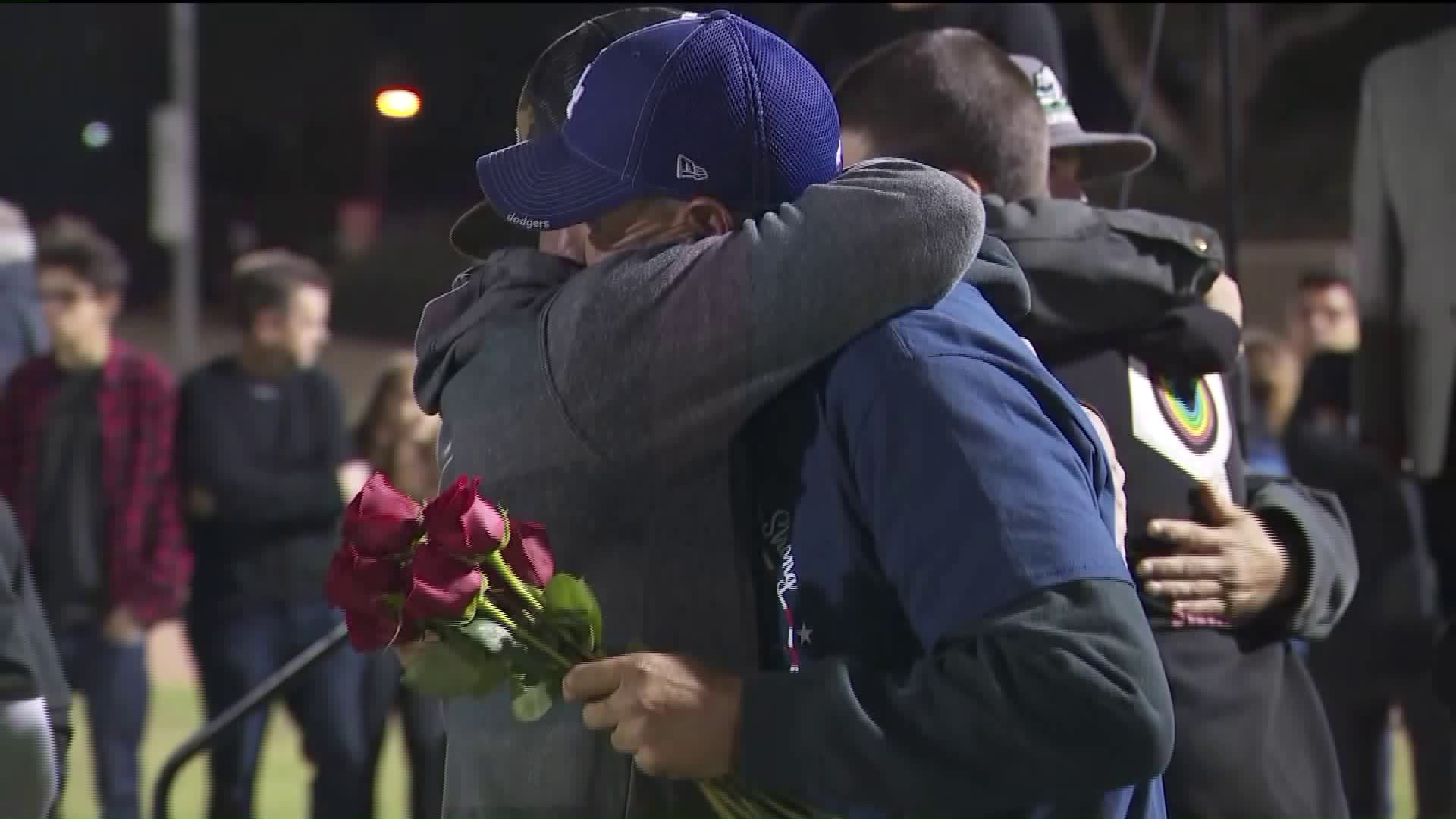 Jason Coffman hands out roses on Nov. 13, 2018, to families during a vigil for the victims of the Thousand Oaks mass shooting. (Credit: KTLA)