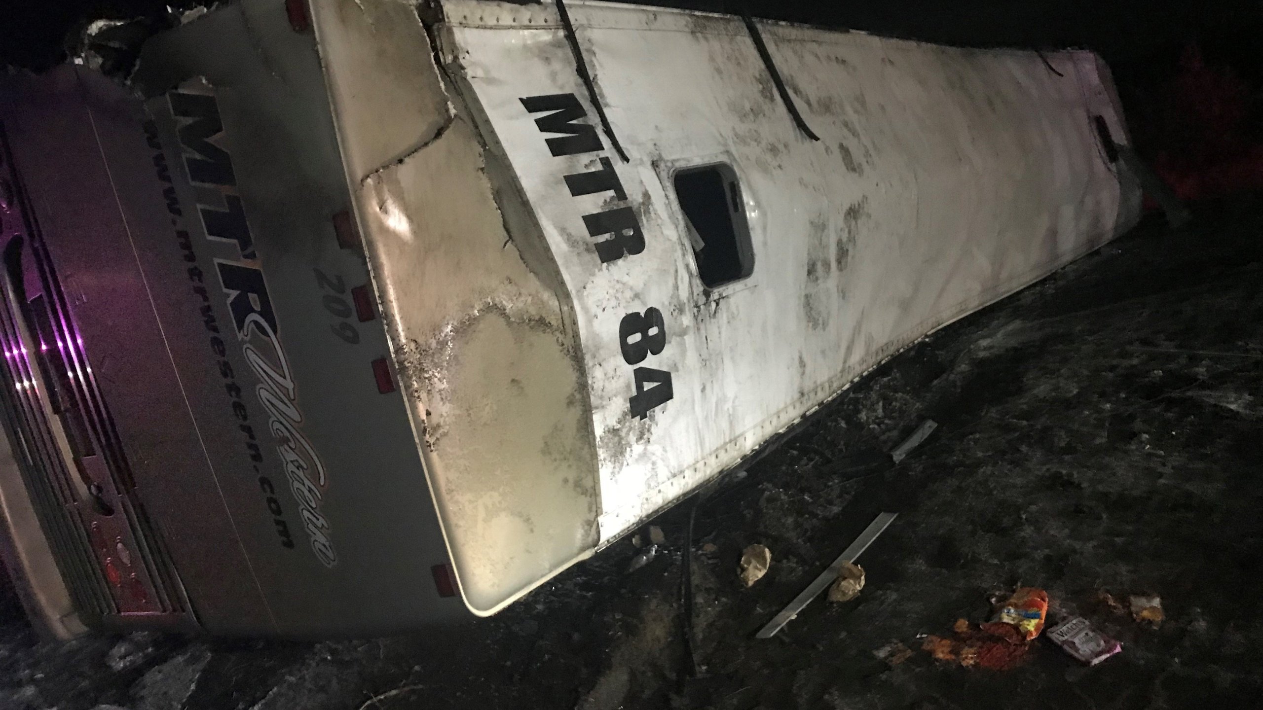 A charter bus carrying members of the University of Washington marching band rolled onto its side Thursday, leaving nearly 40 people injured, state police said. (Credit: KCPQ)