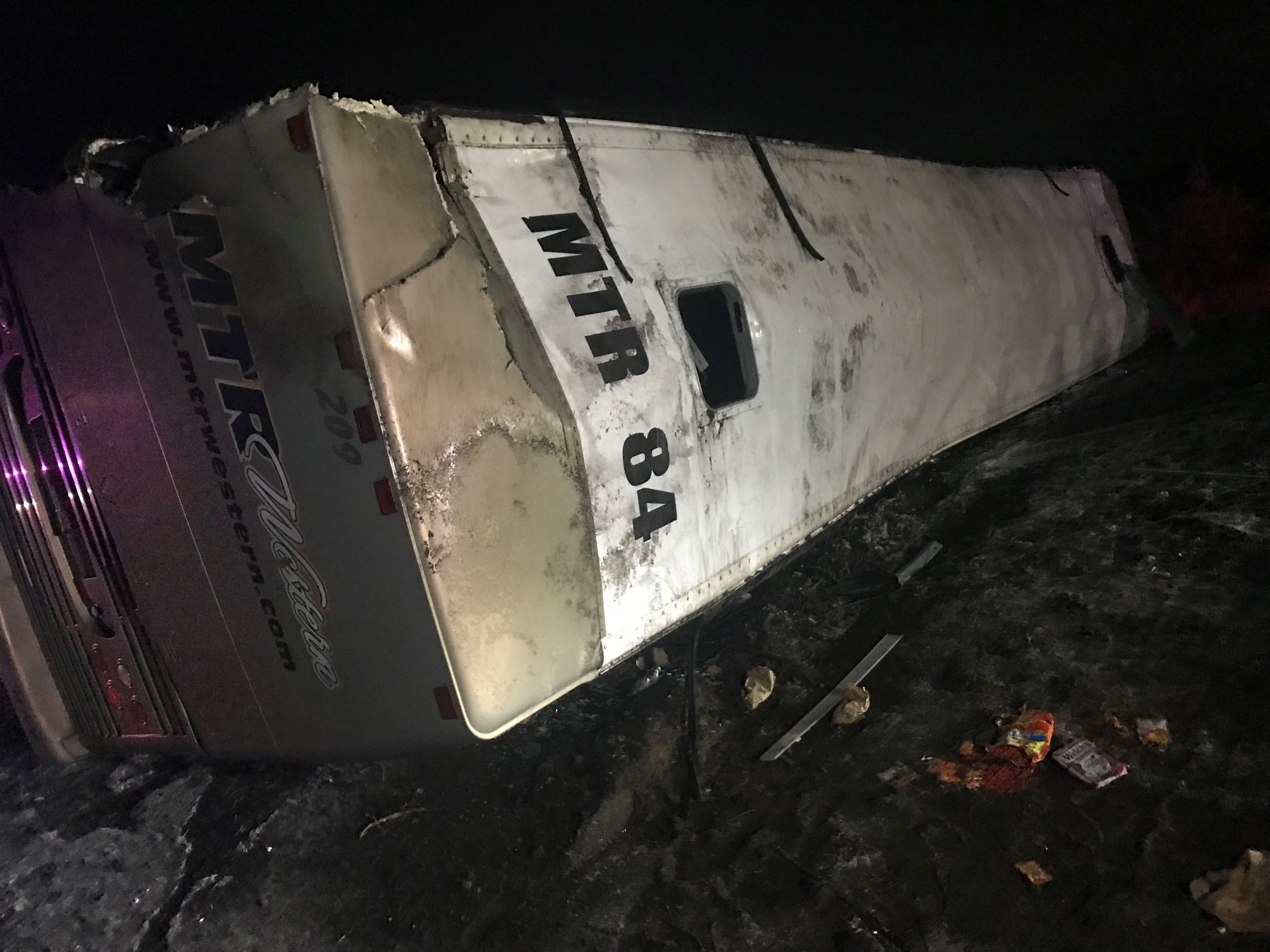 A charter bus carrying members of the University of Washington marching band rolled onto its side Thursday, leaving nearly 40 people injured, state police said. (Credit: KCPQ)