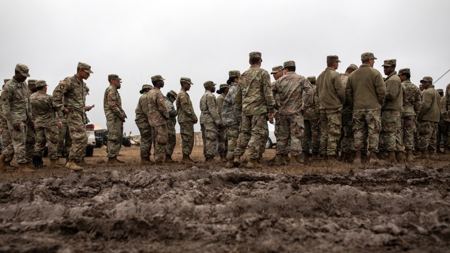 U.S. Army troops deployed to the U.S.-Mexico border line up to receive a Thanksgiving meal at a base near the Donna-Rio Bravo International Bridge on Nov. 22, 2018 in Donna, Texas. (Credit: Tamir Kalifa/Getty Images)