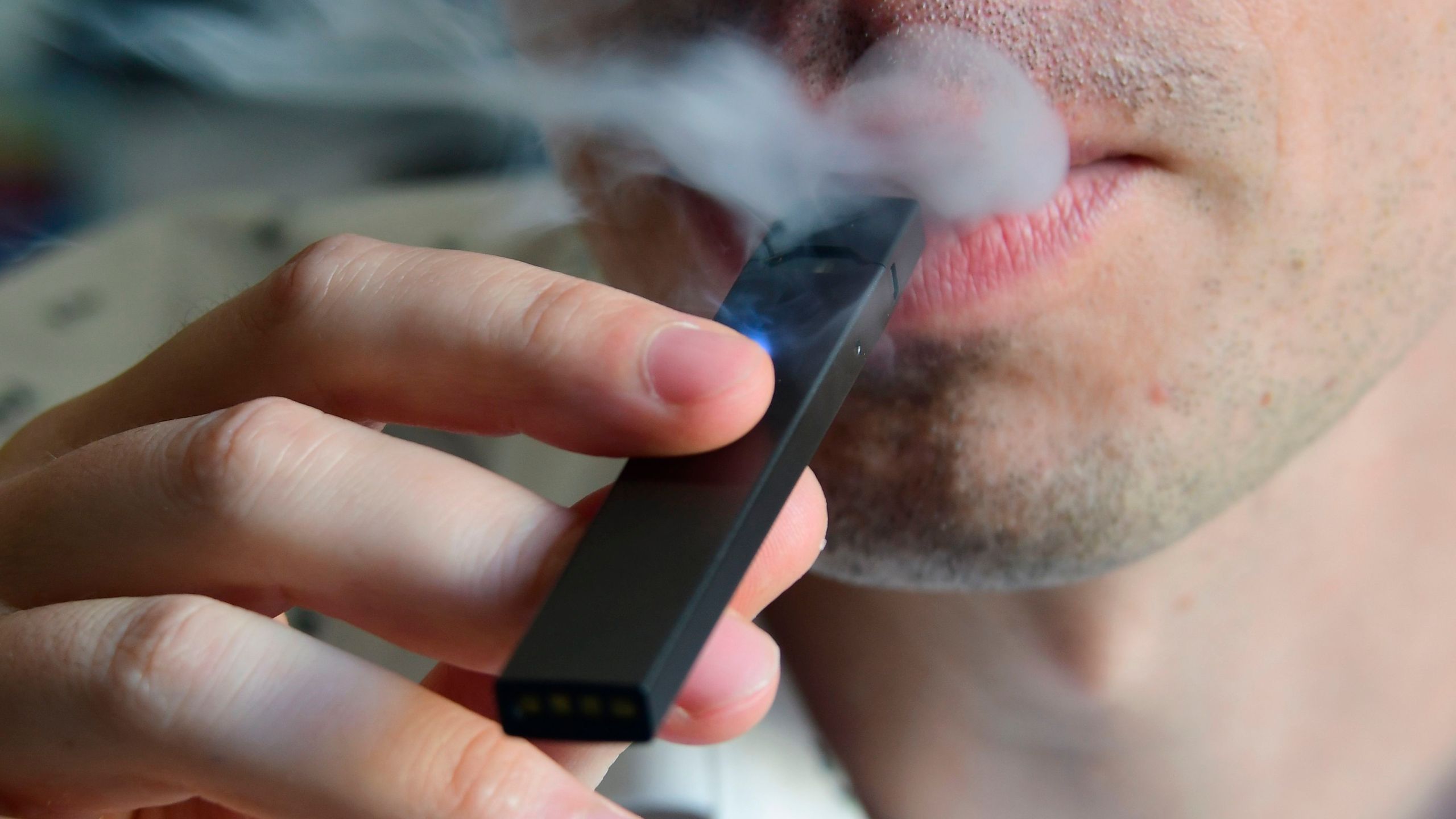 An illustration shows a man exhaling smoke from an electronic cigarette in Washington, DC on October 2, 2018.(Credit: EVA HAMBACH/AFP/Getty Images)