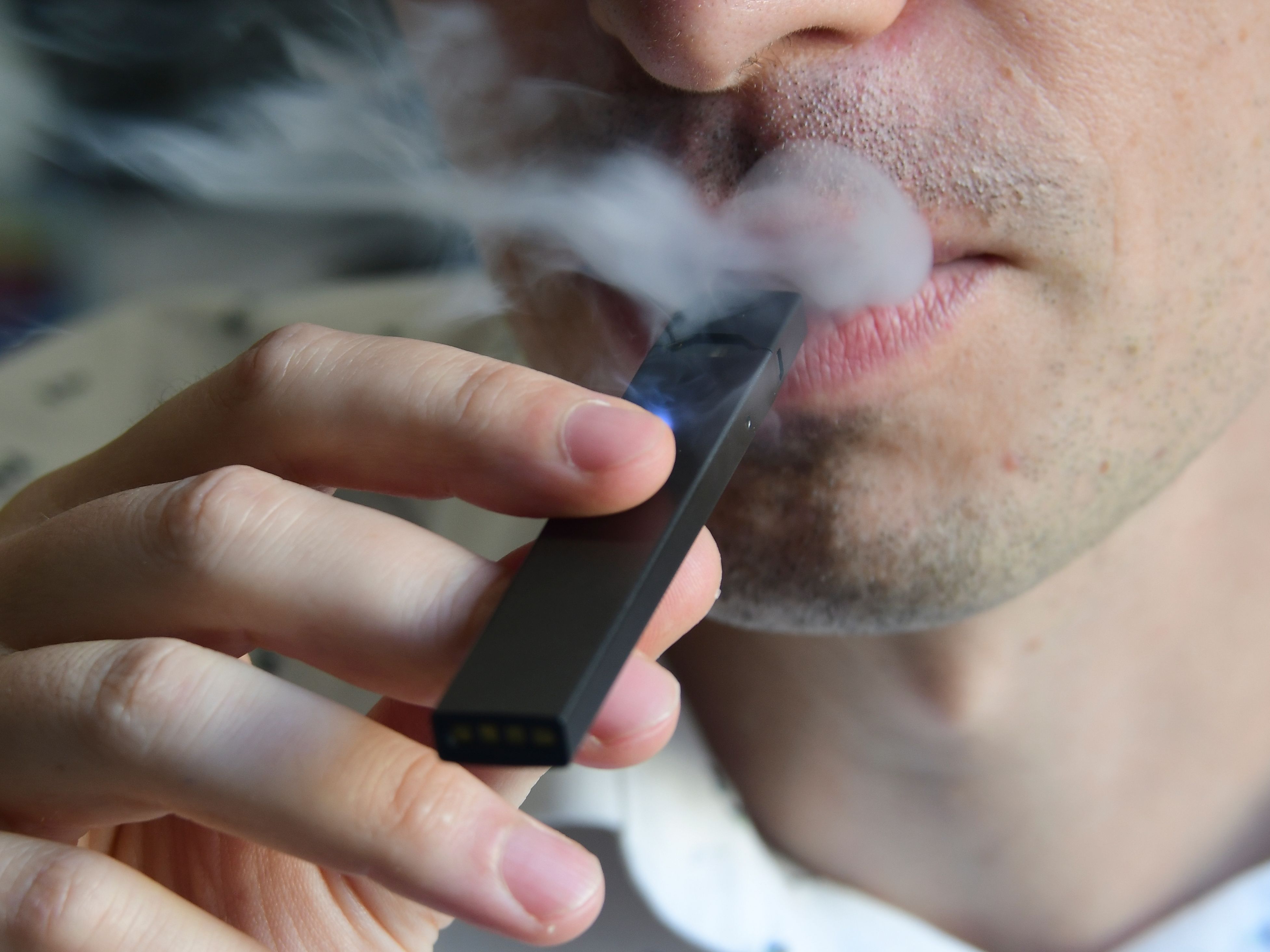 An illustration shows a man exhaling smoke from an electronic cigarette in Washington, DC on October 2, 2018.(Credit: EVA HAMBACH/AFP/Getty Images)